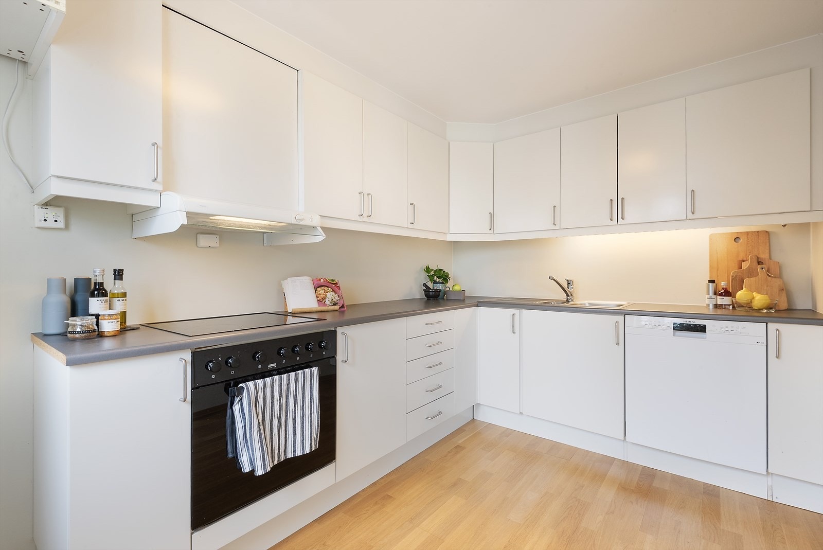 Kjøkken med lys innredning i vinkel. Galleribilde