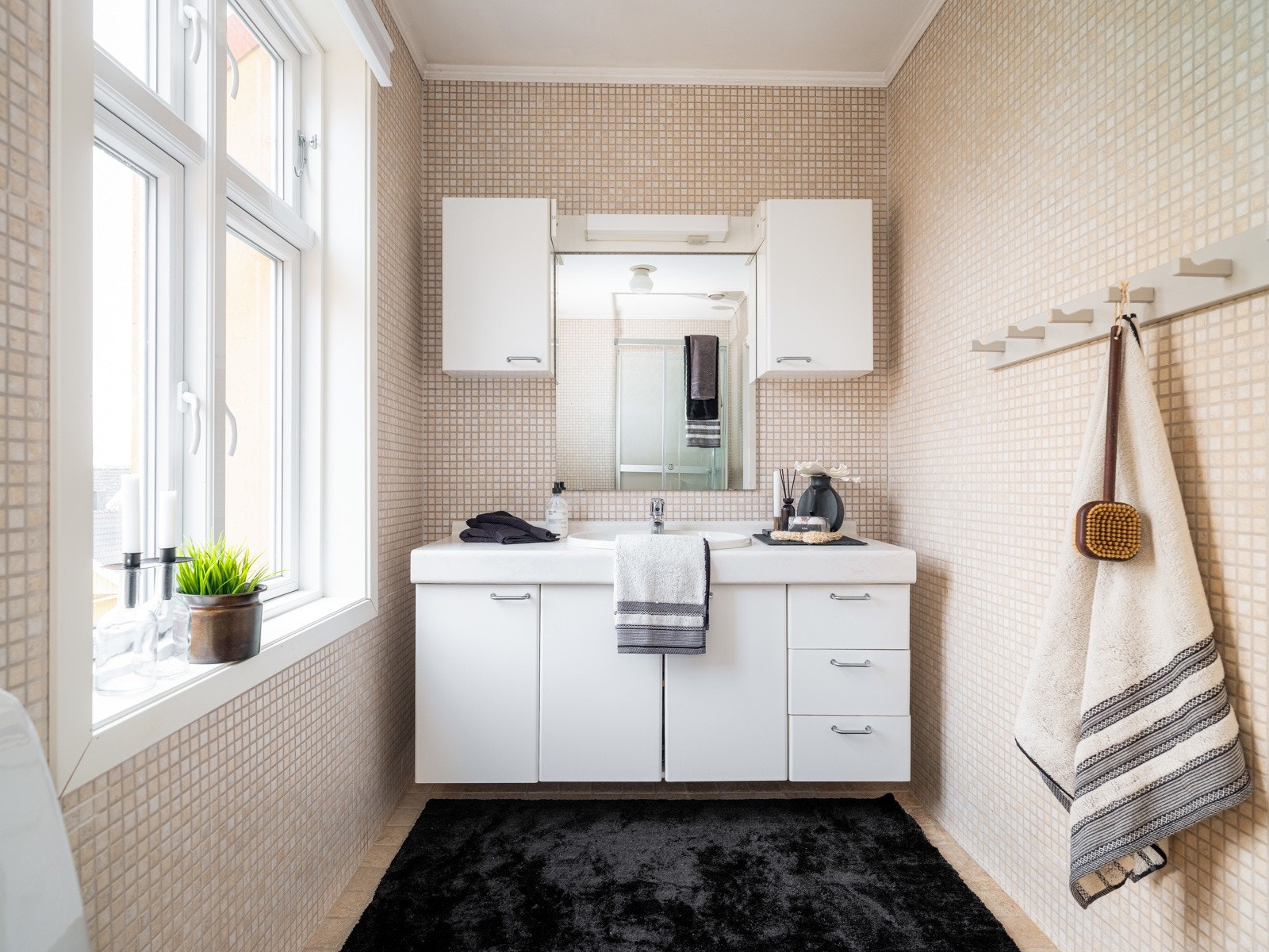 Badet på 5,5 kvm er praktisk innredet med stor servant og baderomsmøbel med god oppbevaringsplass. Galleribilde