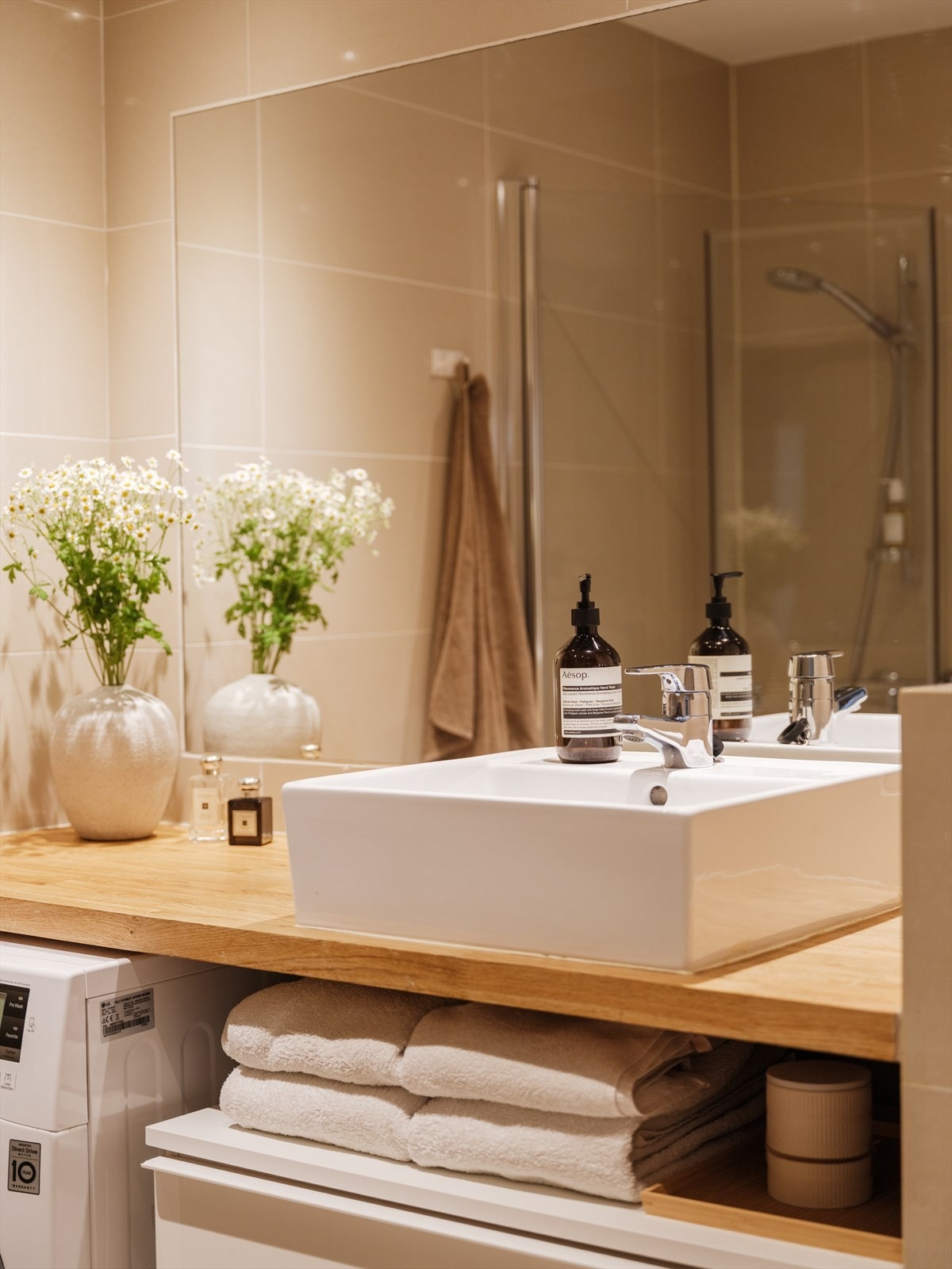 Det er flislagte gulv- og veggoverflater. Under benken er det opplegg for vaskemaskin. Galleribilde