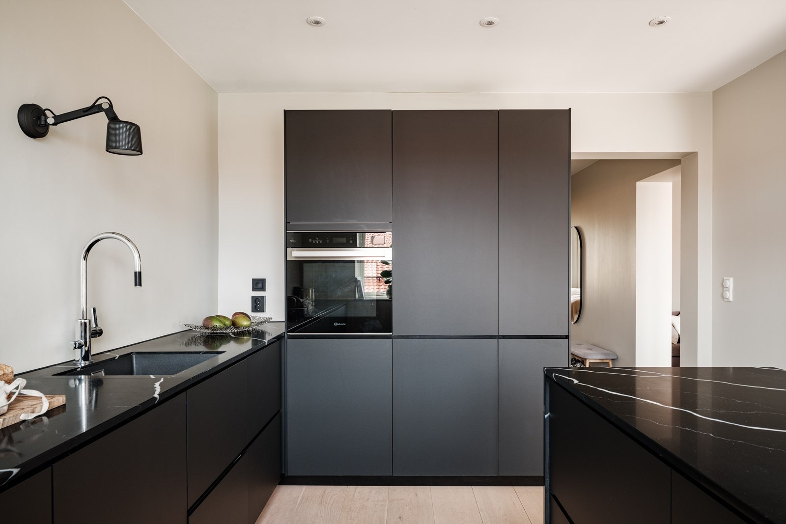 Innredningen har glatte, mørke fronter og benkeplate i eksklusiv steinkompositt med underlimt kum i slitesterk plastkompositt. Galleribilde