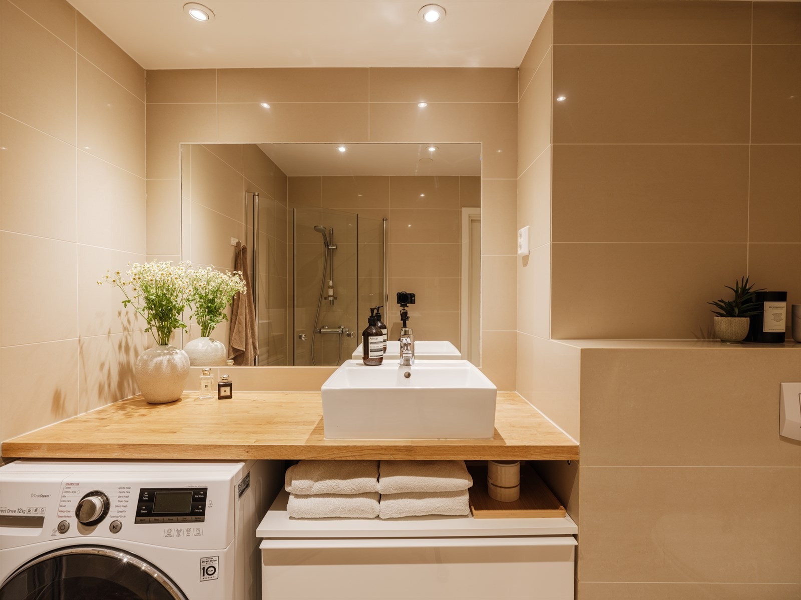 Rommet fremstår delikat med store, ensfargede fliser på både gulv og vegger, og det er varmekabler i gulvet. Galleribilde