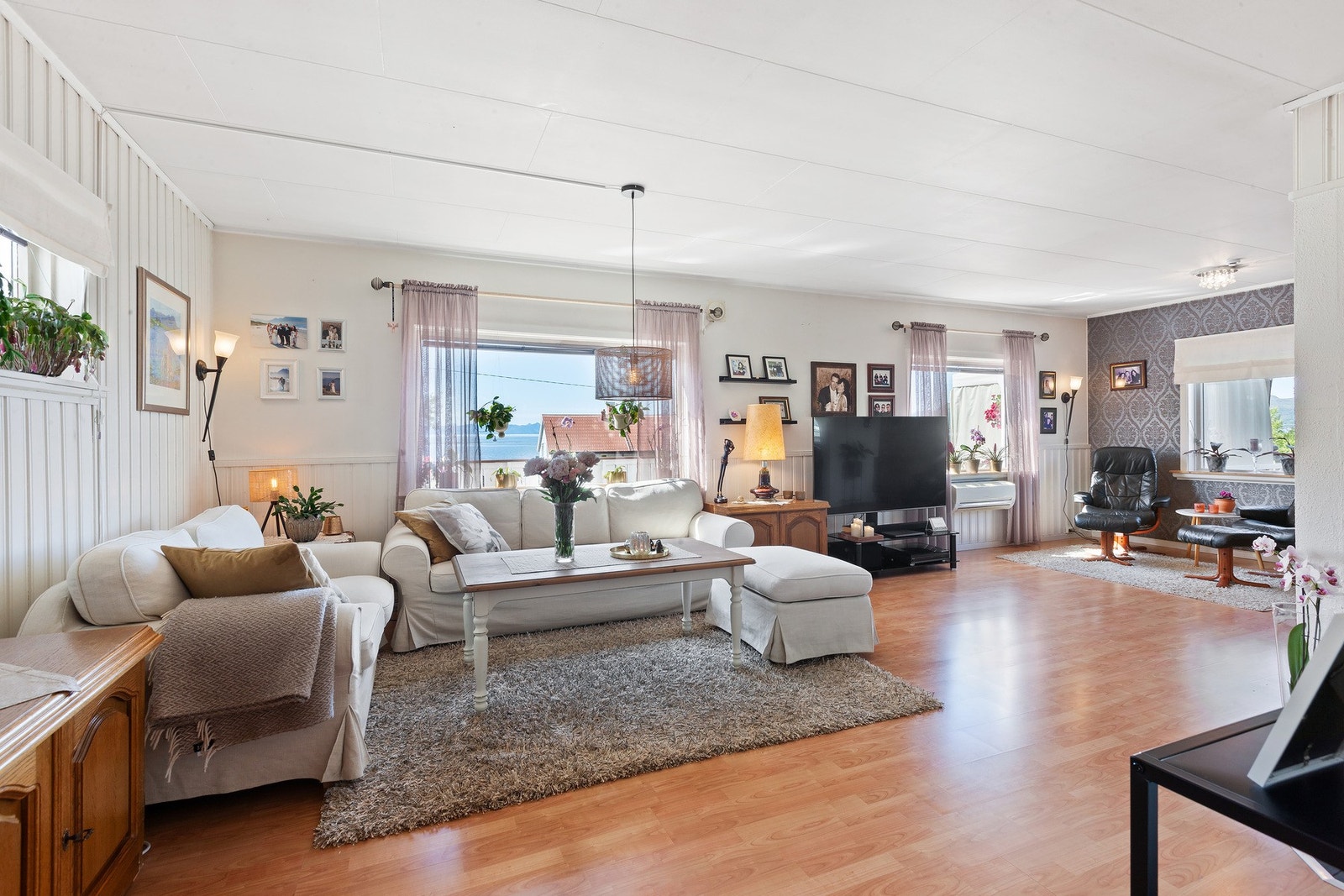 Stuen har lyse overflater og en kontrastvegg på den ene kortsiden. Galleribilde