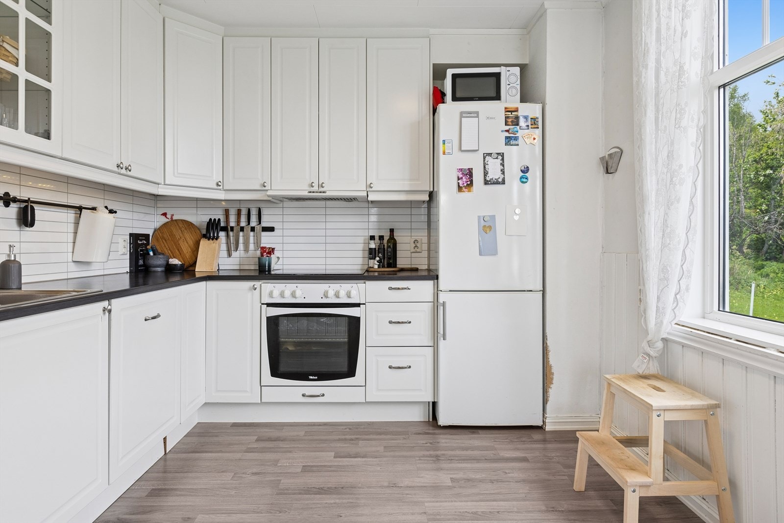 - Ikea kjøkkeninnredning fra ca 2012 med hvite profilerte fronter og en kledelig mørk beneplate. Galleribilde