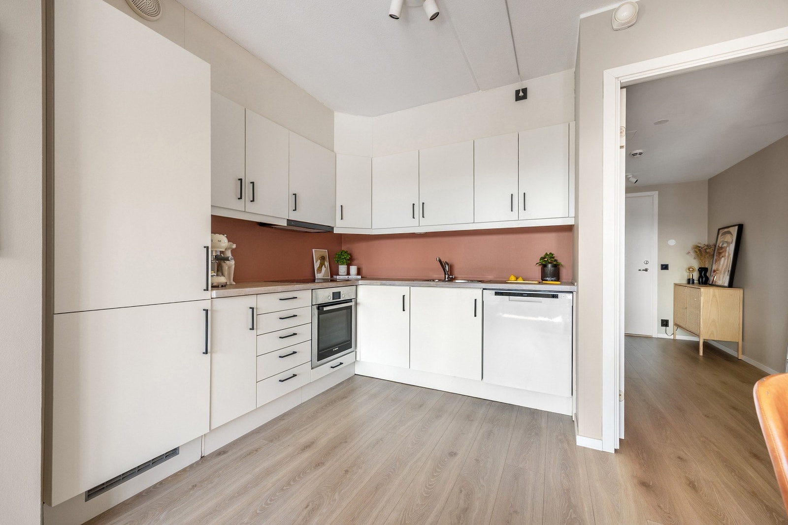 Kjøkkeninnredning med finerte fronter, benkeplate i eik, belysning under overskap, integrert kjøl/frys og ny ventilator fra 2023. Galleribilde