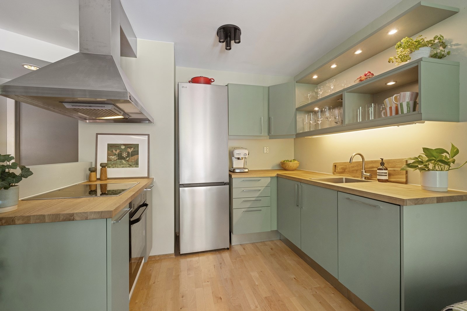 Pent kjøkken fra HTH med innredning fra 2003 og oppgradert i 2025 med nymalte, glatte fronter og benkeplate i tre. Galleribilde