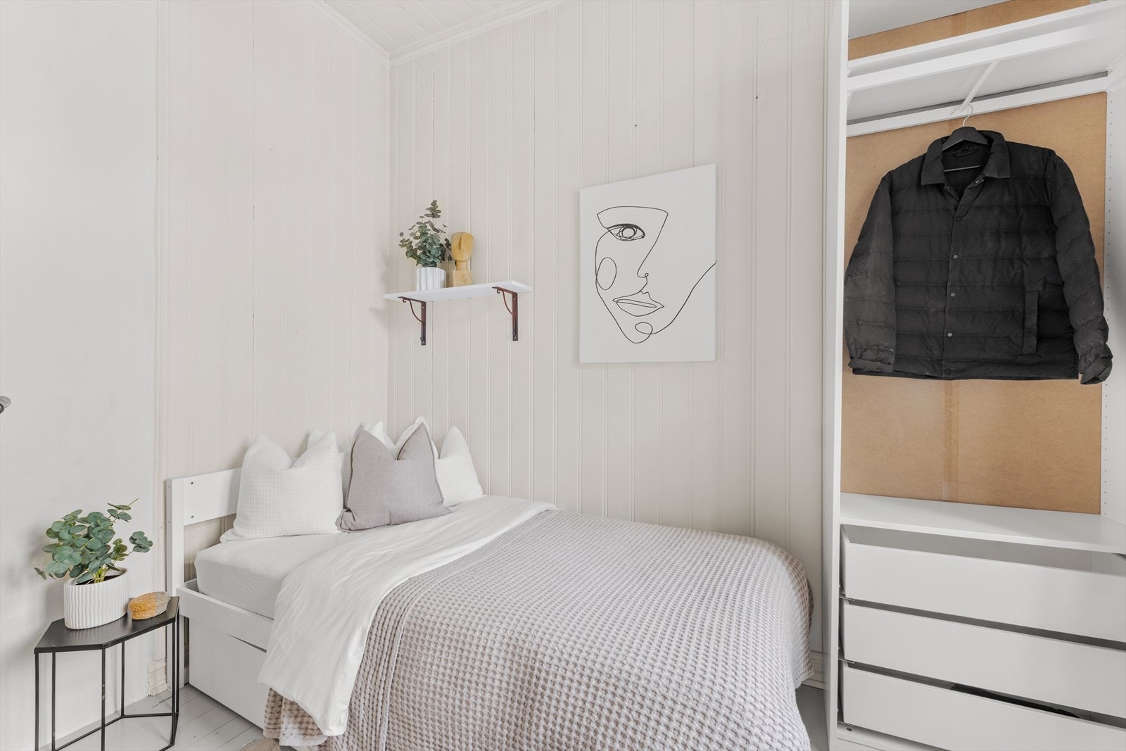 Soverom med plass til seng. Det er montert åpen garderobeløsning med stang, skuffer og hyller. Galleribilde