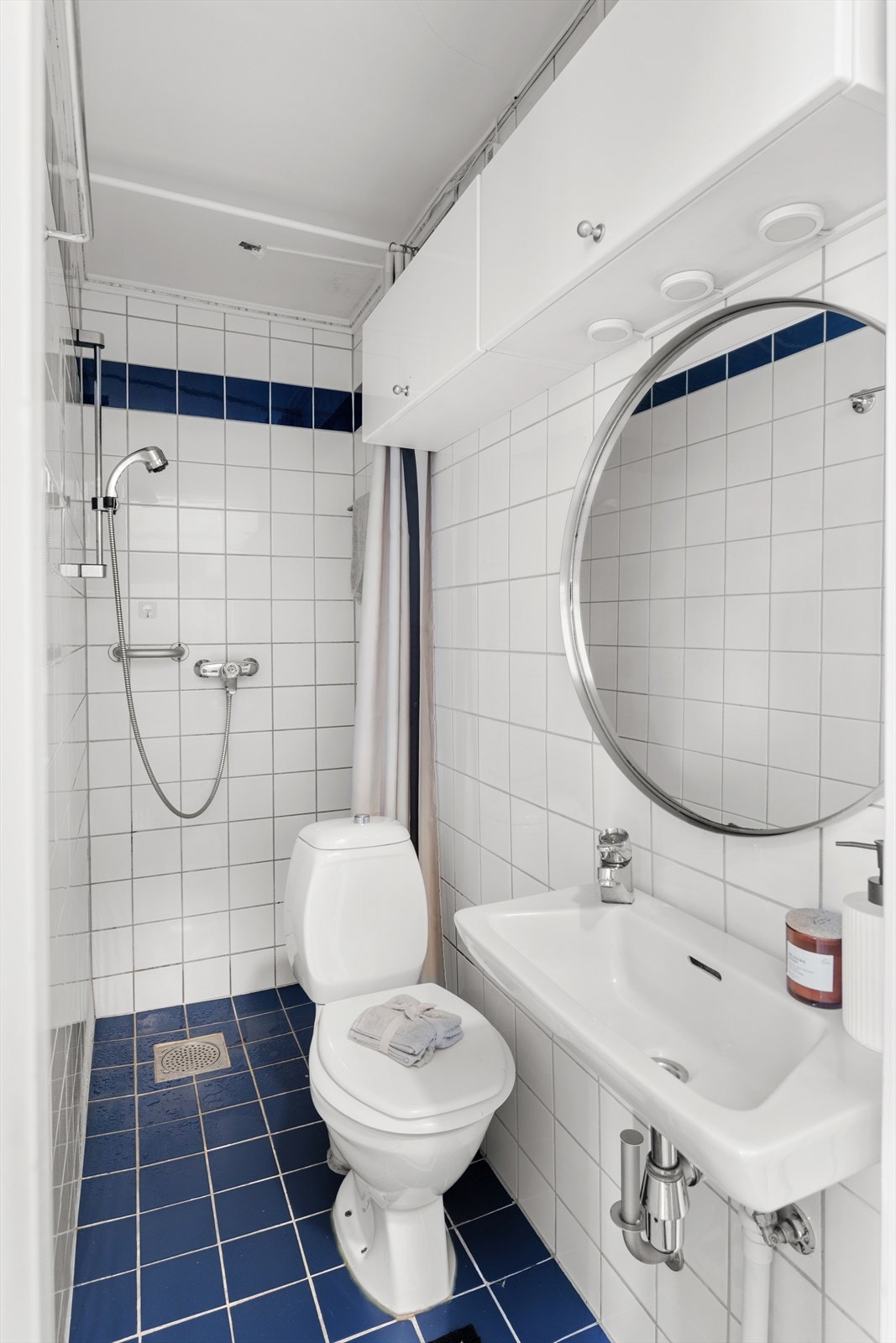 Flislagt baderom med elektriske varmekabler i gulv. Badet er utstyrt med dusjhjørne, servant og gulvstående toalett. Galleribilde