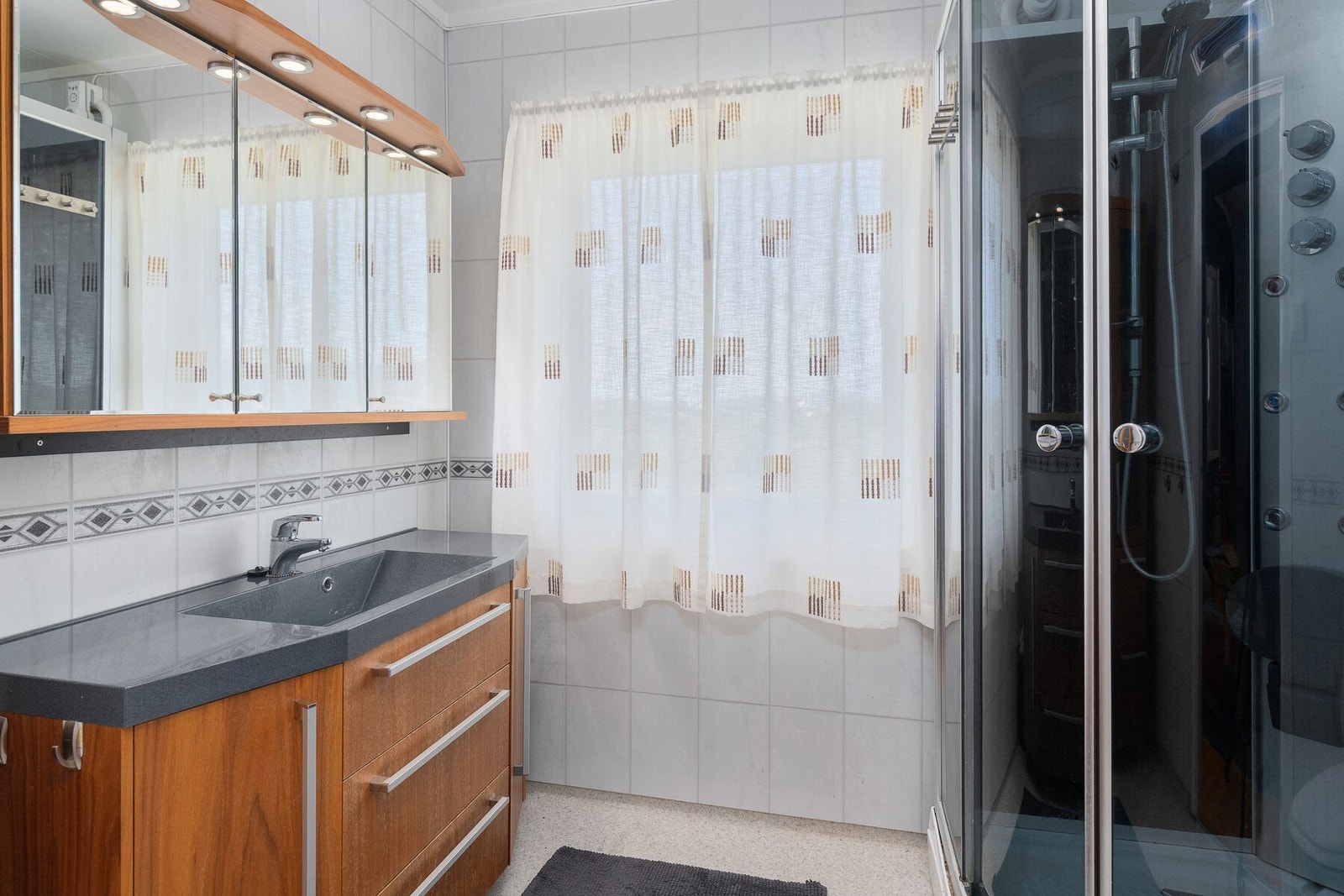 Badet ble fornyet på innvendige flater og utstyr i 2013. Rommet er utstyrt med servant på innredning, toalett og dusjkabinett. Galleribilde