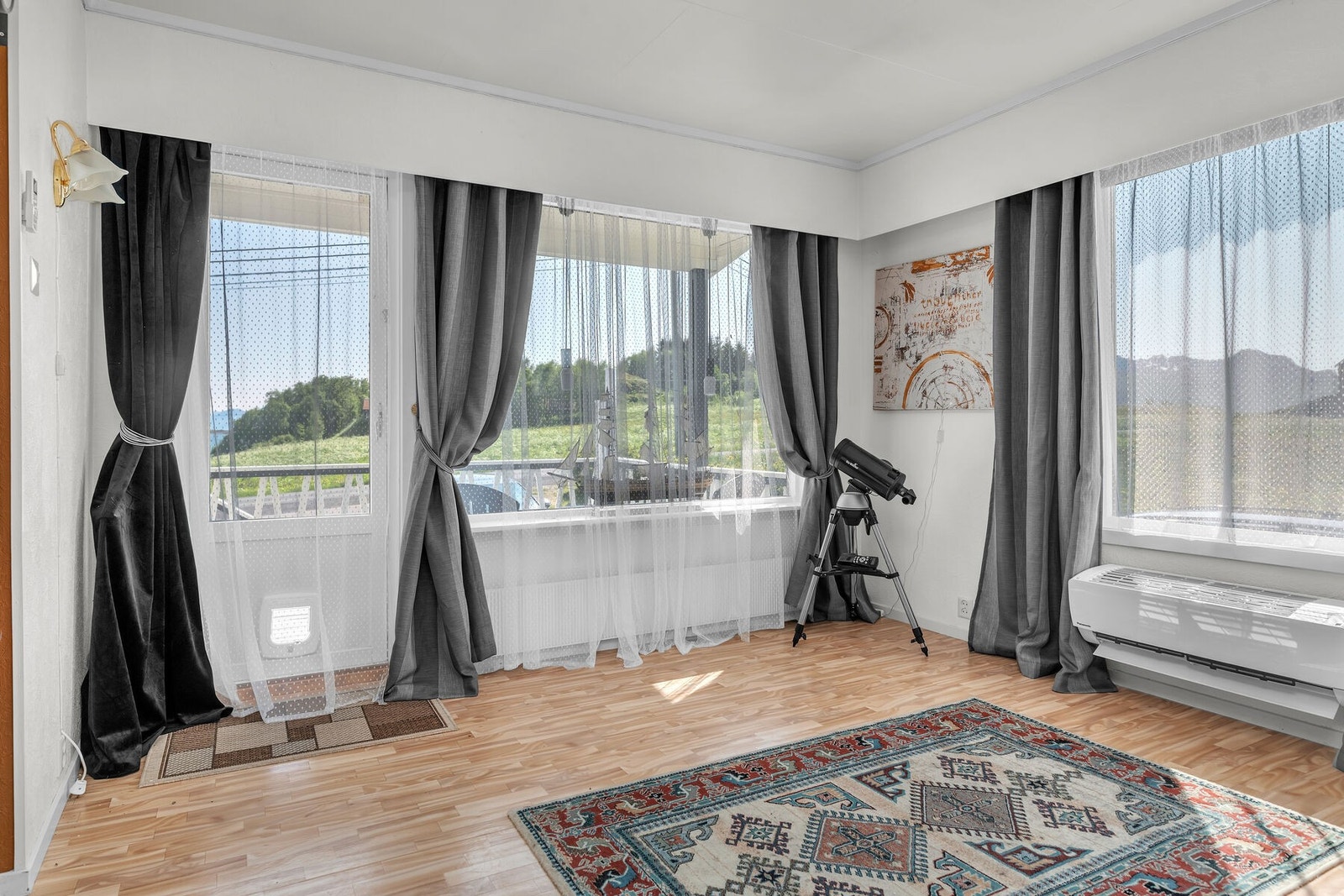 Stuen har store vinduer som gir mye lys og naturskjønn utsikt. Galleribilde