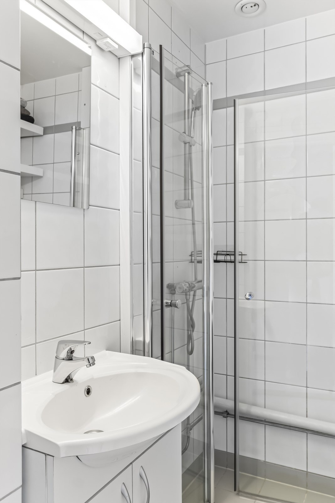 Innredningen består av benkeskap med glatte fronter og vegghengte hyller for ekstra oppbevaring.
Dusjen har innfellbare dører i herdet glass. Badet er ellers utstyrt med servant, gulvstående toalett og opplegg for vaskemaskin. Galleribilde