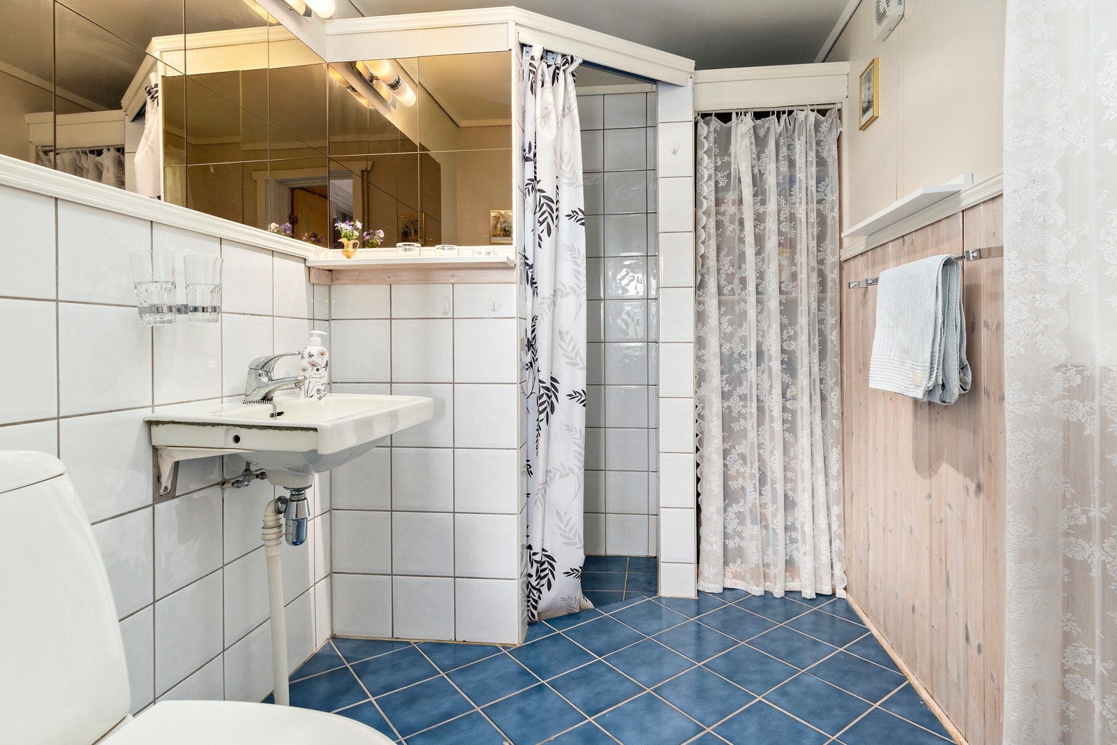 Badet er flislagt og har dusj, servant og toalett. Galleribilde