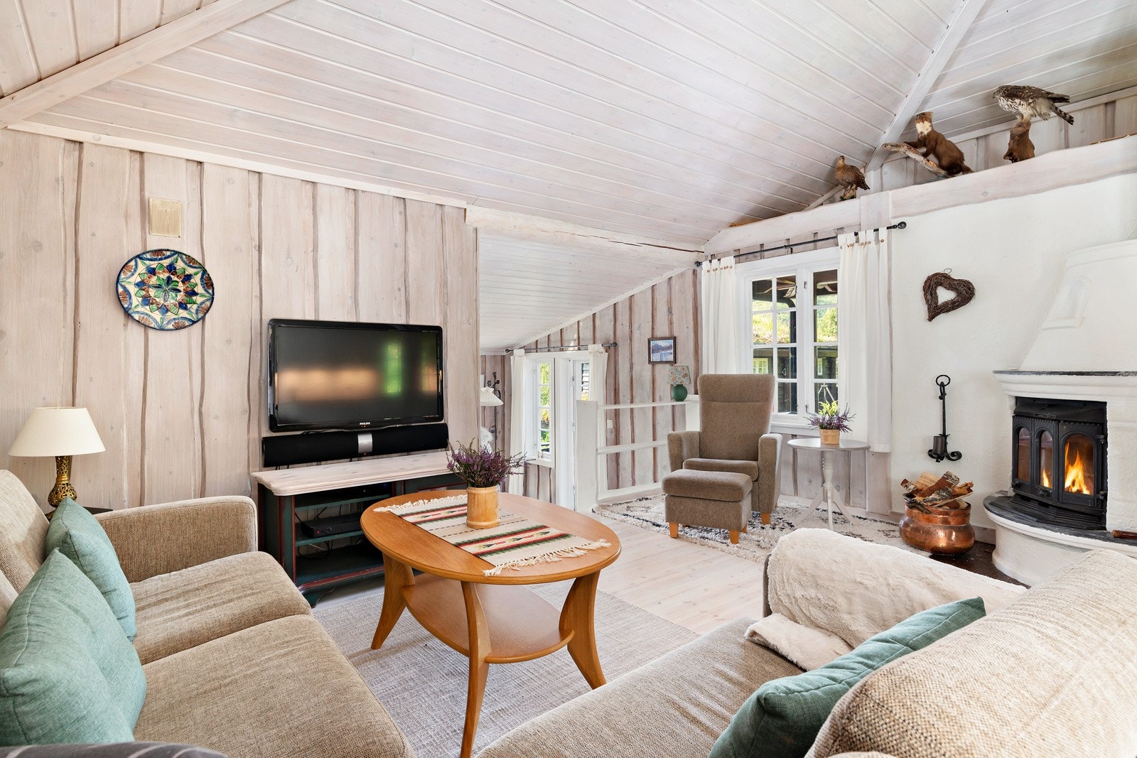 Det er plass til en romslig sofagruppe ved peisen. Galleribilde