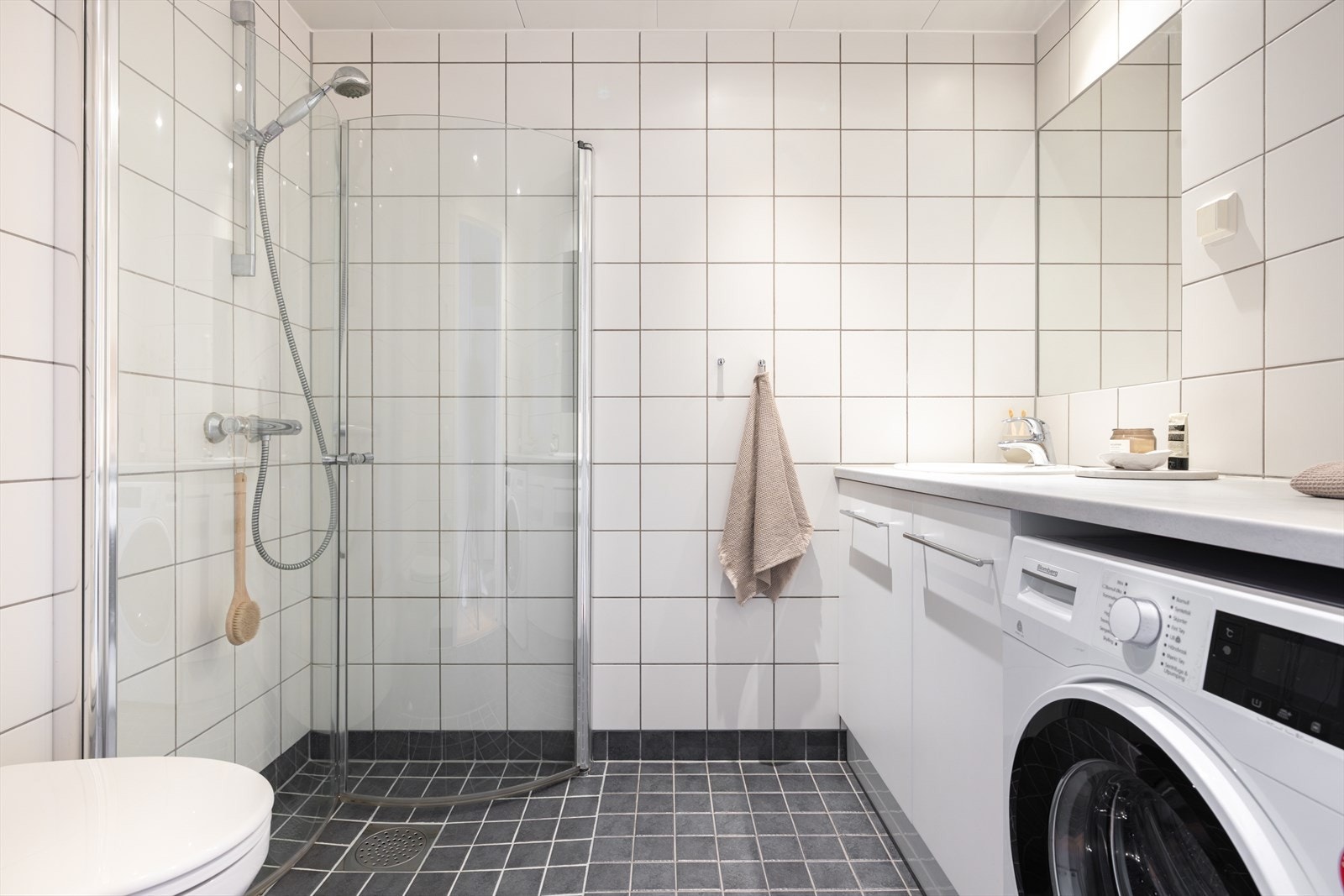 Lyst og pent flislagt bad med varmekabler i gulvet og dimbare spotter i taket. Galleribilde