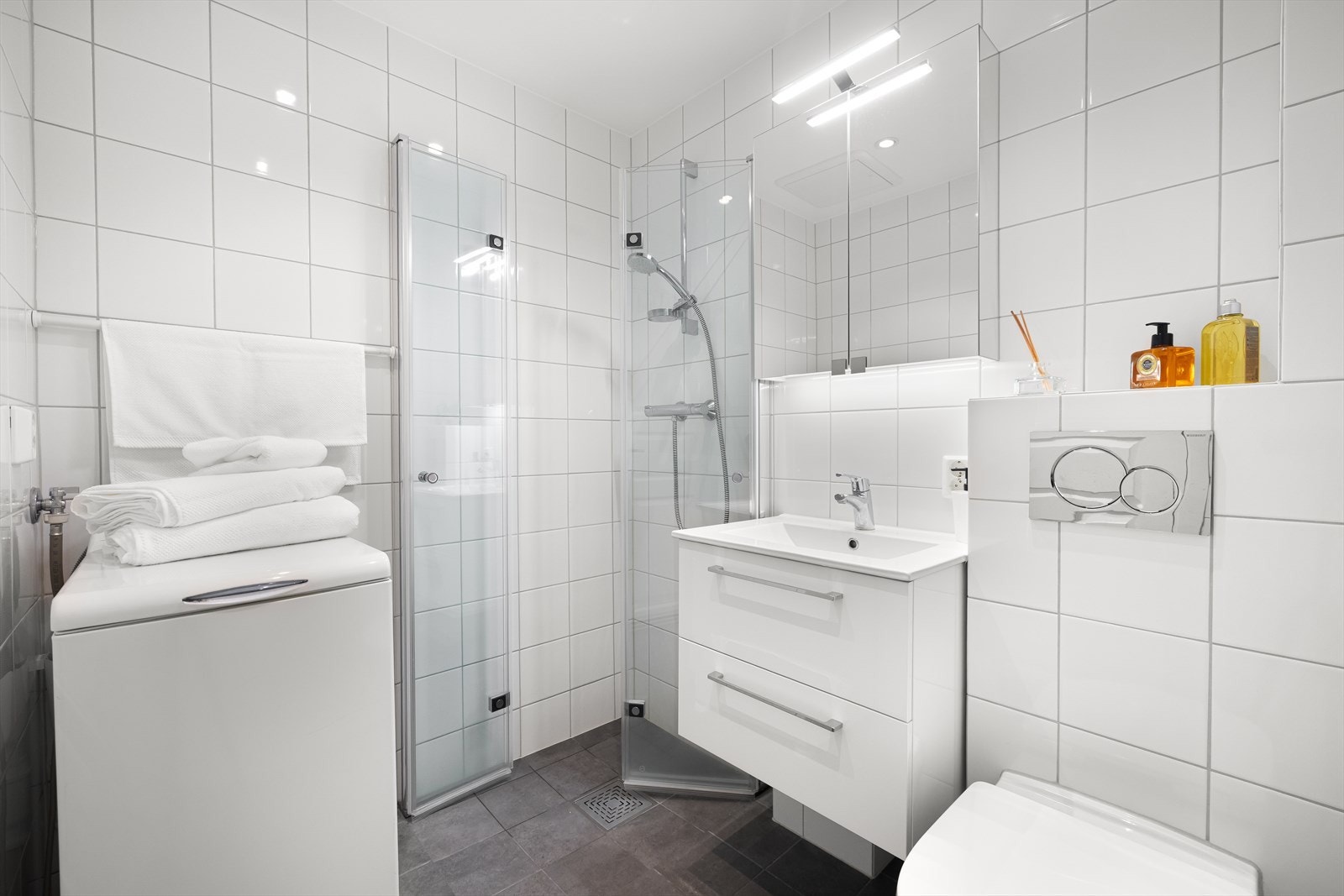 Delikat og moderne baderom, flislagt og oppgradert i regi av selger i 2023 og rørfornying i regi av borettslaget i 2023. Badet har gulvvarme og downlights i himlingen. Praktisk dusjhjørne rett på gulv med foldedører i glass, dusjbatteri og hånddusj. Galleribilde