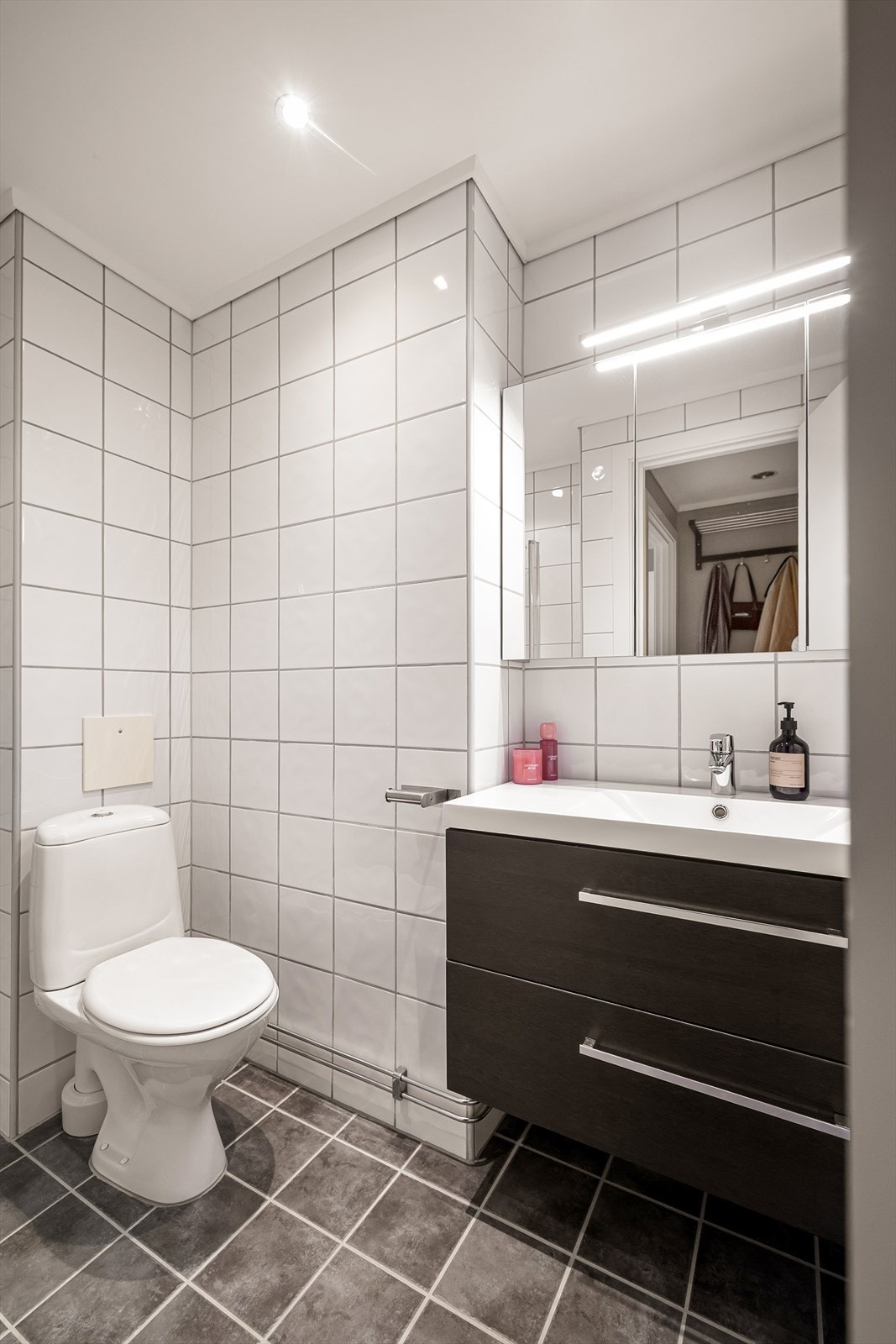 Pent, tidløst bad med flislagte overflater, behagelig gulvvarme og downlights i himling. Galleribilde