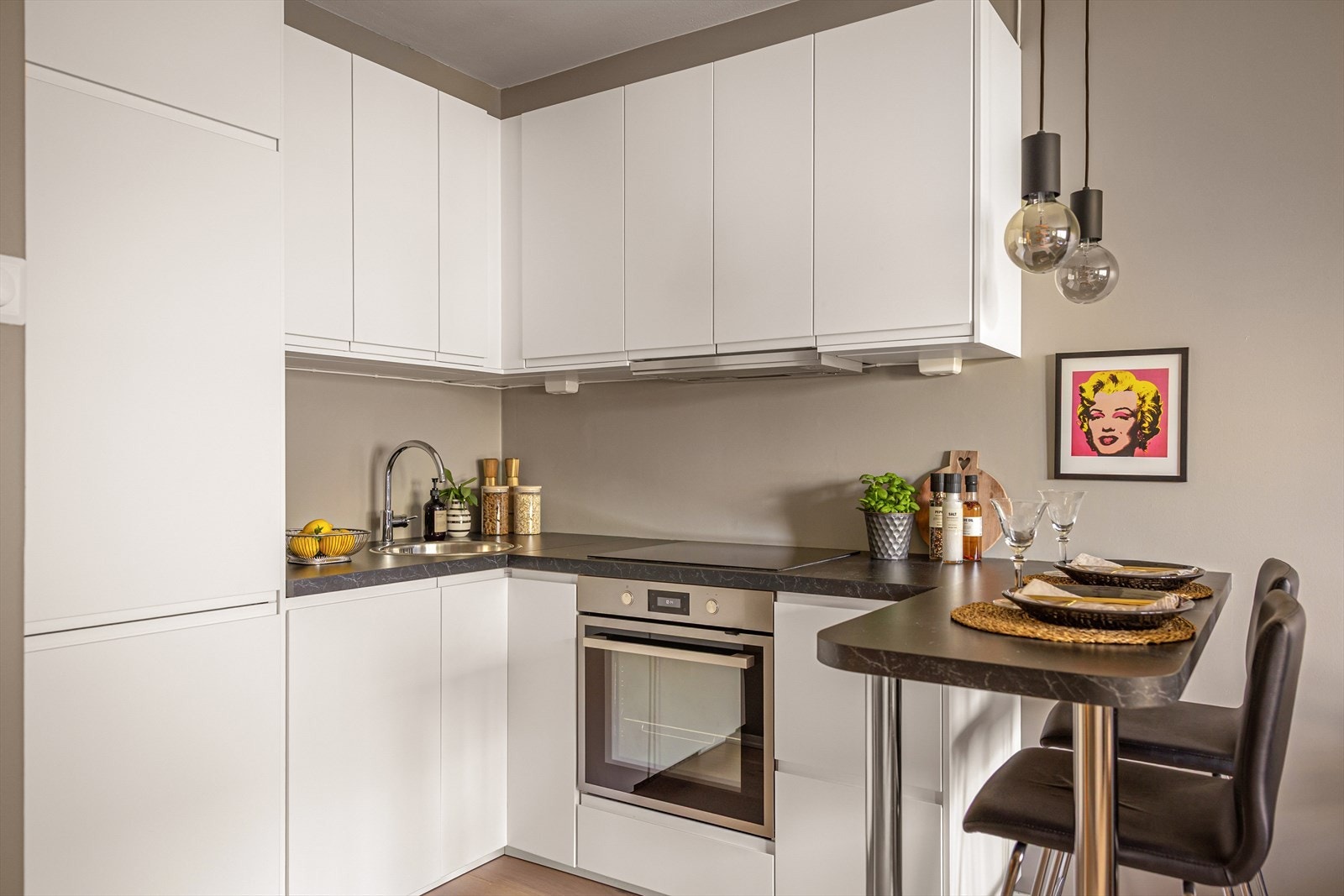 Moderne og stilsikkert kjøkken fra 2019. Innredning fra Ikea med hvite, glatte fronter og benkeplate i laminat. Galleribilde