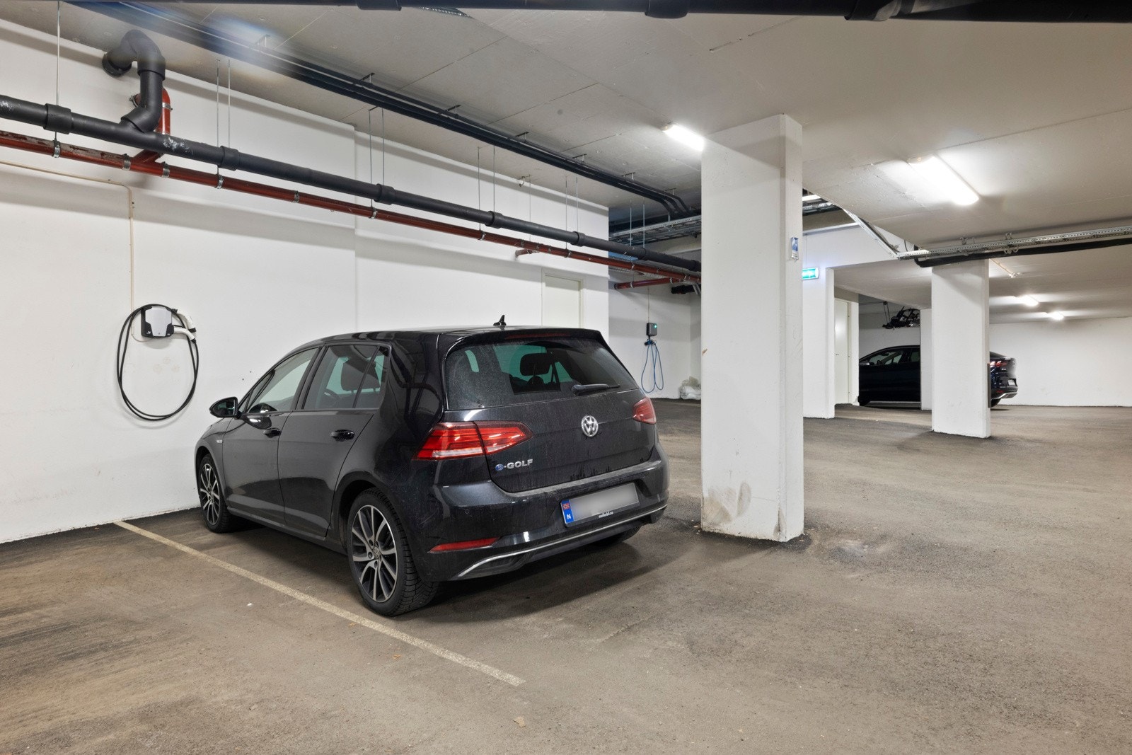 Innendørs parkeringsplass med elbillader. Galleribilde