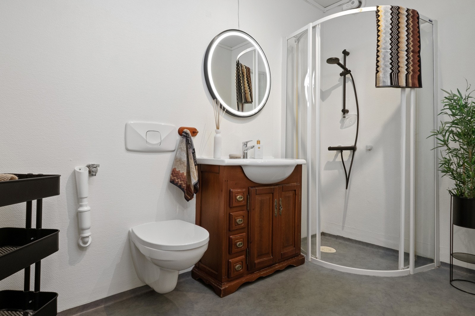 Badet er innredet med hvitmalte vegger og grått vinylbelegg på gulvet. Galleribilde