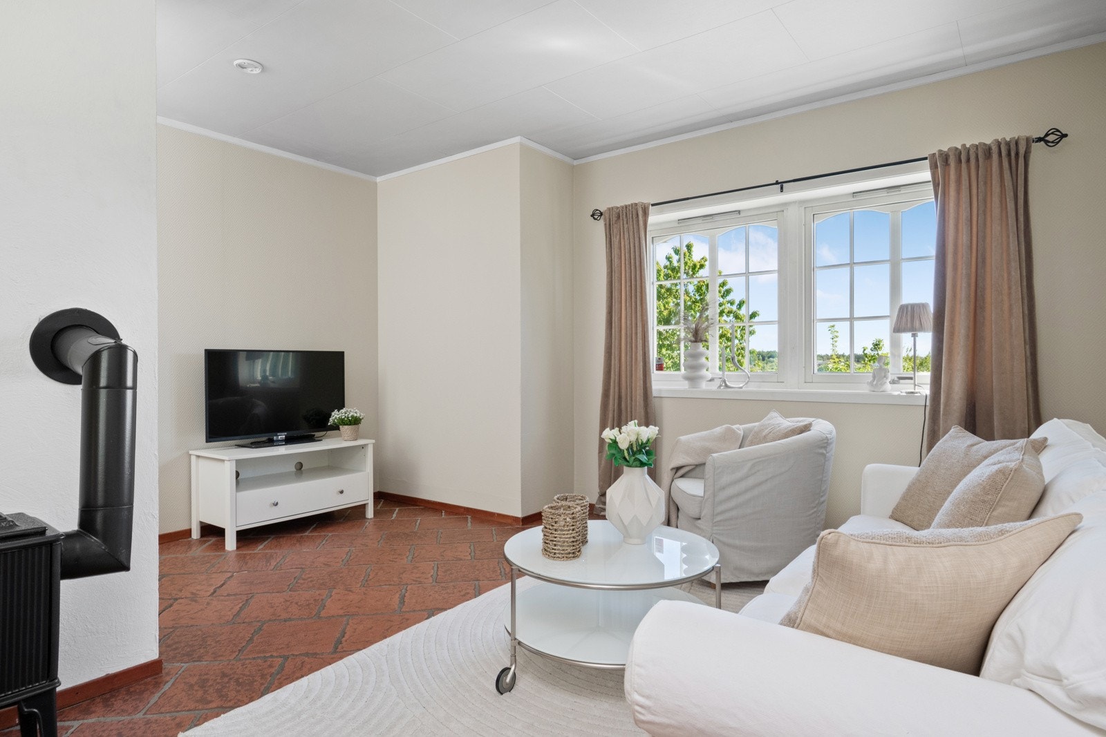 Stuen og kjøkkenet ligger i åpen løsning, med vedovn og plass til flere sittegrupper. Galleribilde