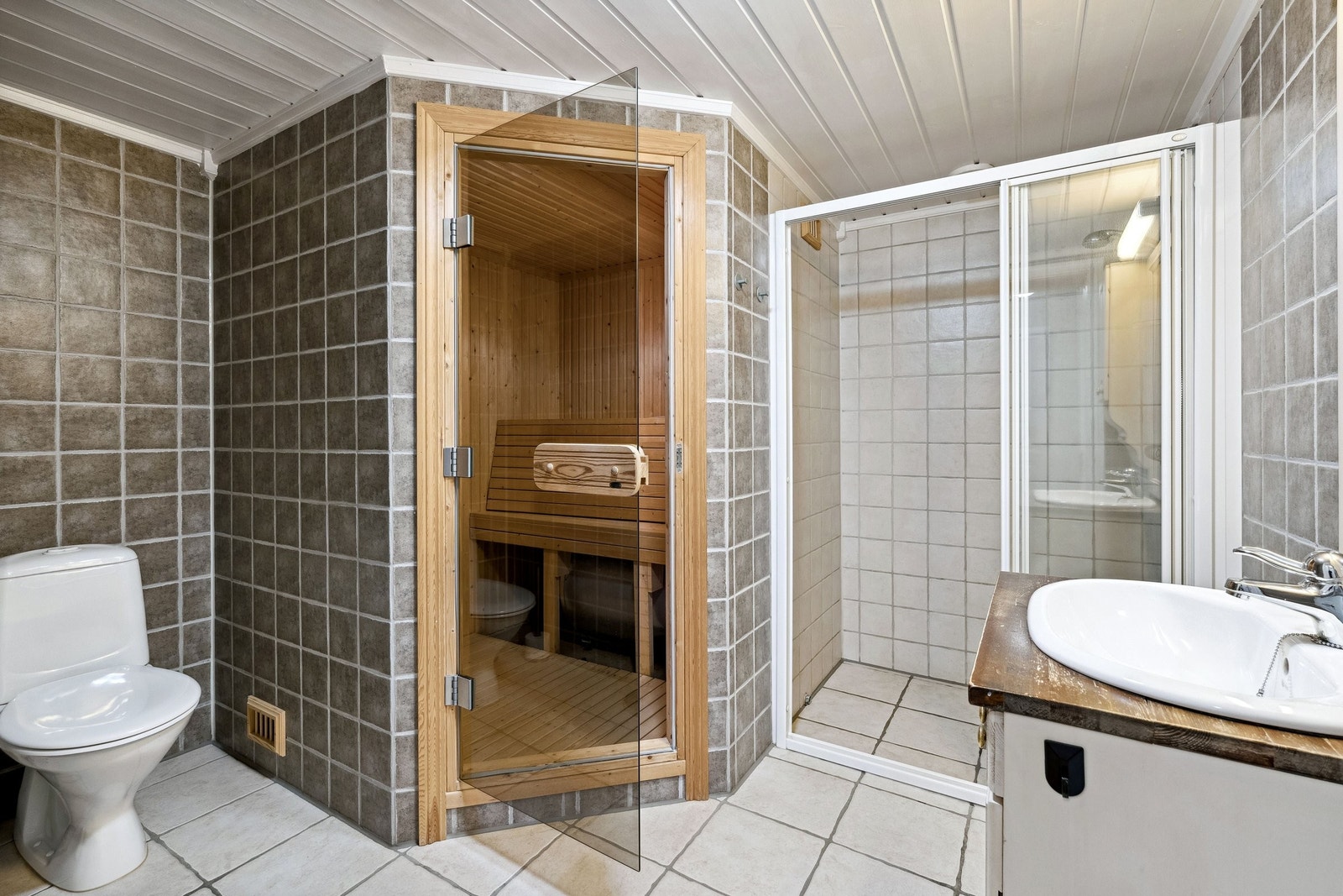 Stor dusj, innebygd badstue og opplegg for vaskemaskin mellom servant og dusj Galleribilde