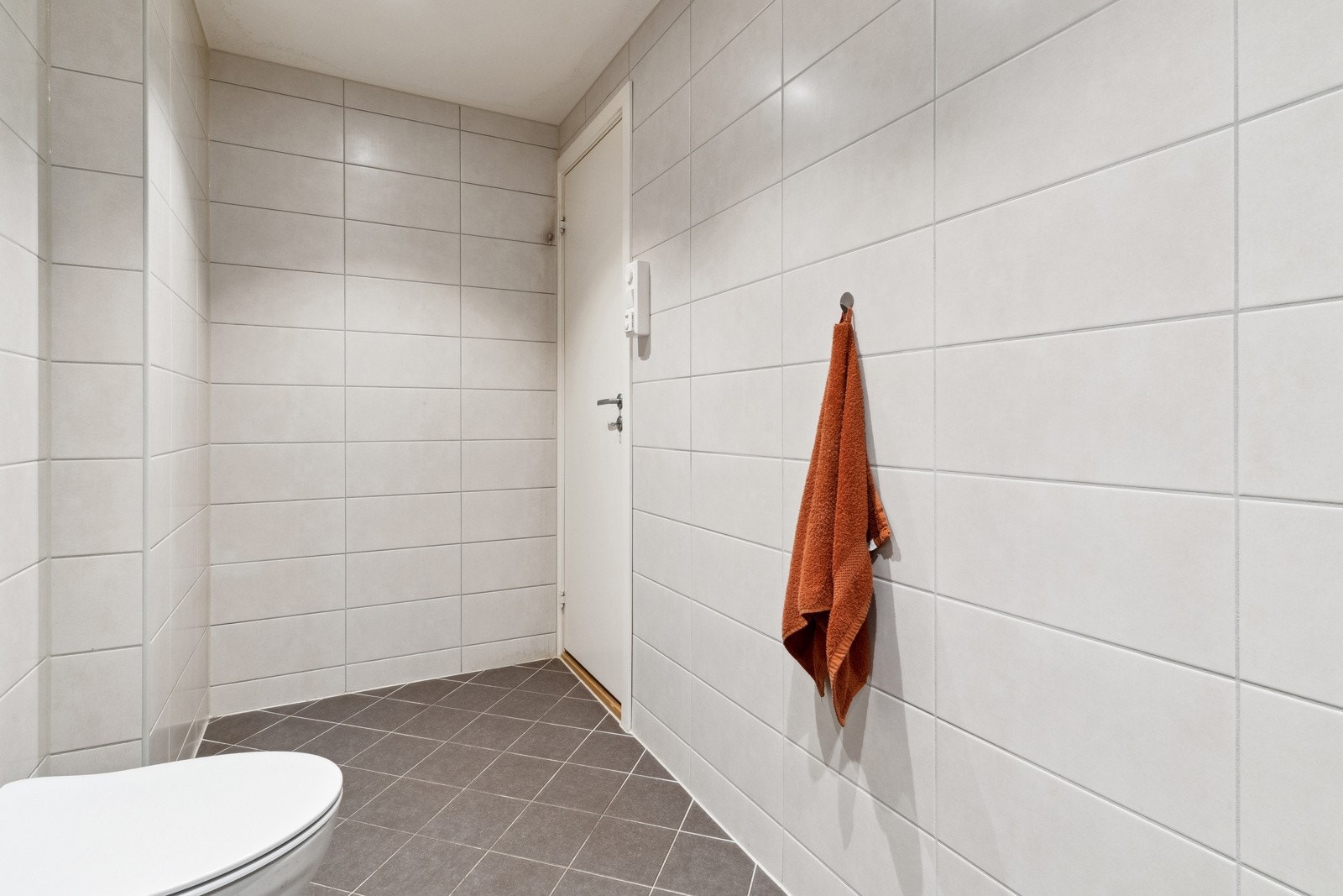 Badet har flislagt gulv med gulvvarme, flislagte vegger og himling av malt flate med downlights. Galleribilde