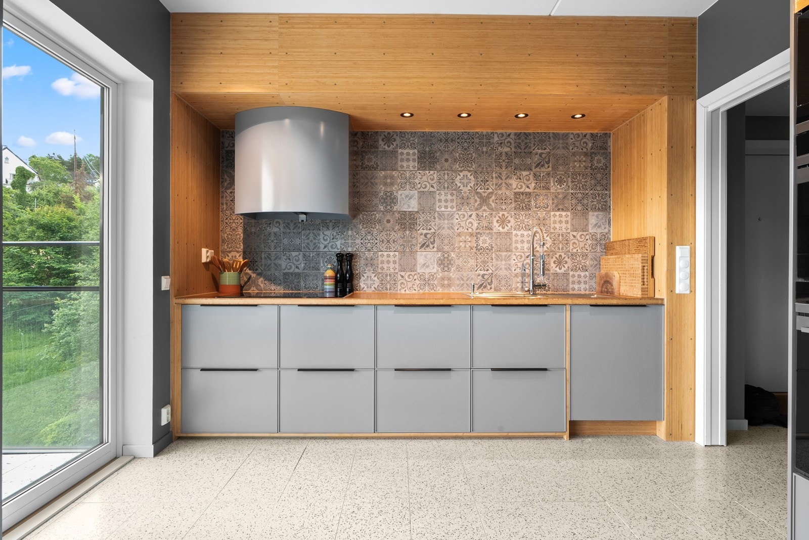 Det er lagt lekre fliser over kjøkkenbenken. Stikkontakt og USB-ladepunkt på vegg og stikkontakt innfelt i benkeplaten. Galleribilde