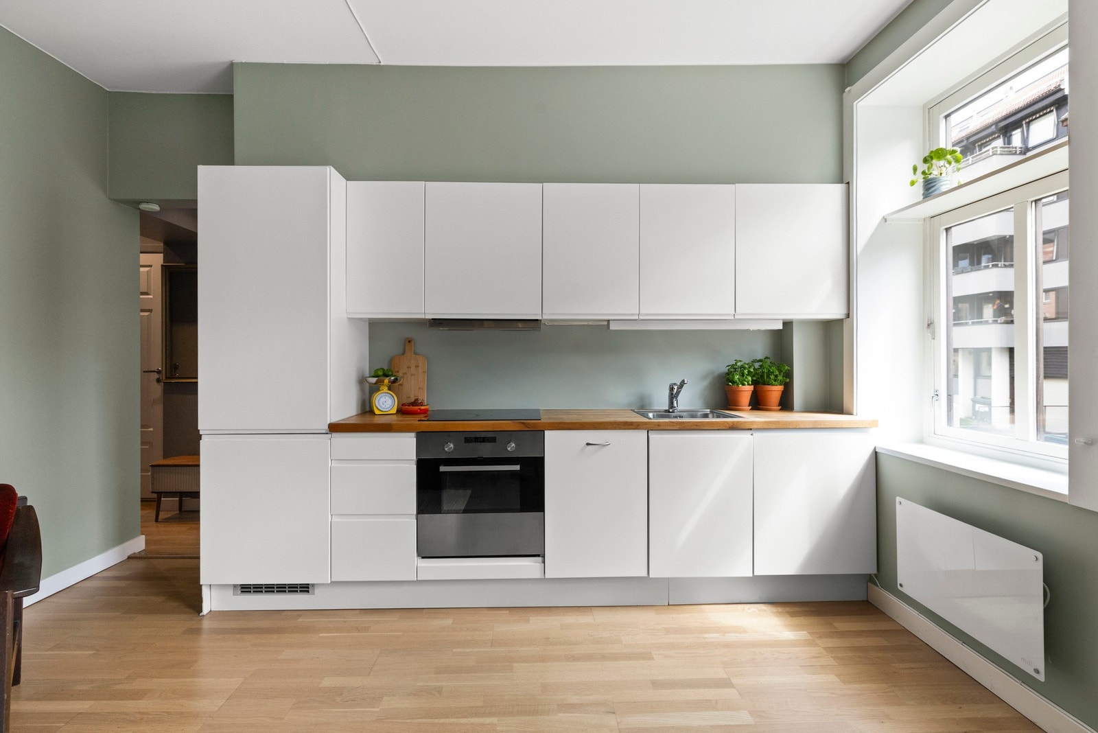 - Pent kjøkken med glatte fronter og heltre benkeplate med integrert kjøkkenkum - Galleribilde