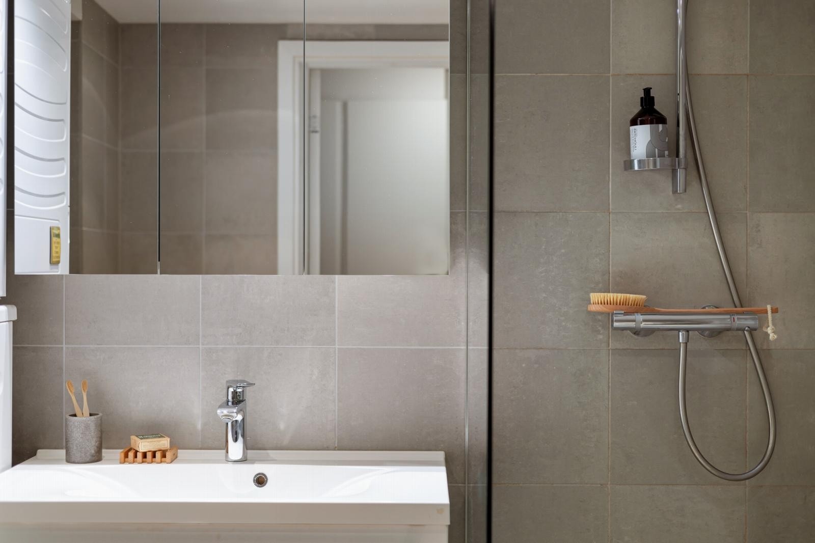 Badet har flislagt gulv med vannbåren gulvvarme og tidløse flislagte vegger. Galleribilde