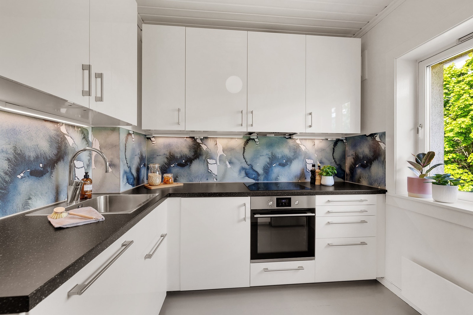 God plass til oppbevaring av kjøkkenredskaper i store over -og underskap samt gode arbeidsflater for matlaging. Galleribilde