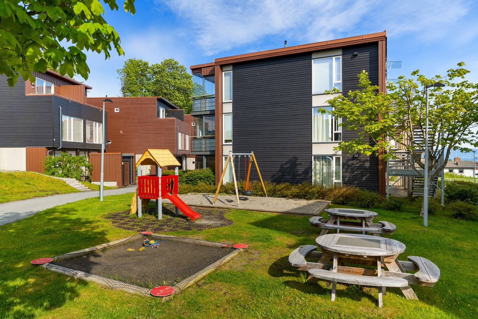 Flotte fellesarealer i borettslaget med lekeplass og sittebenker. Galleribilde