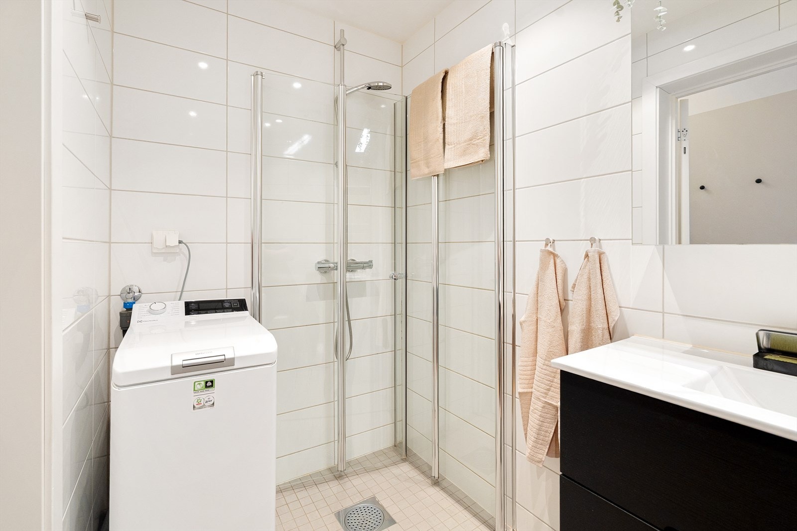 Badet er innredet med veggmontert WC, dusjplass med inn-utadslående dusjvegger, og servant med ettgreps blandebatteri. Galleribilde