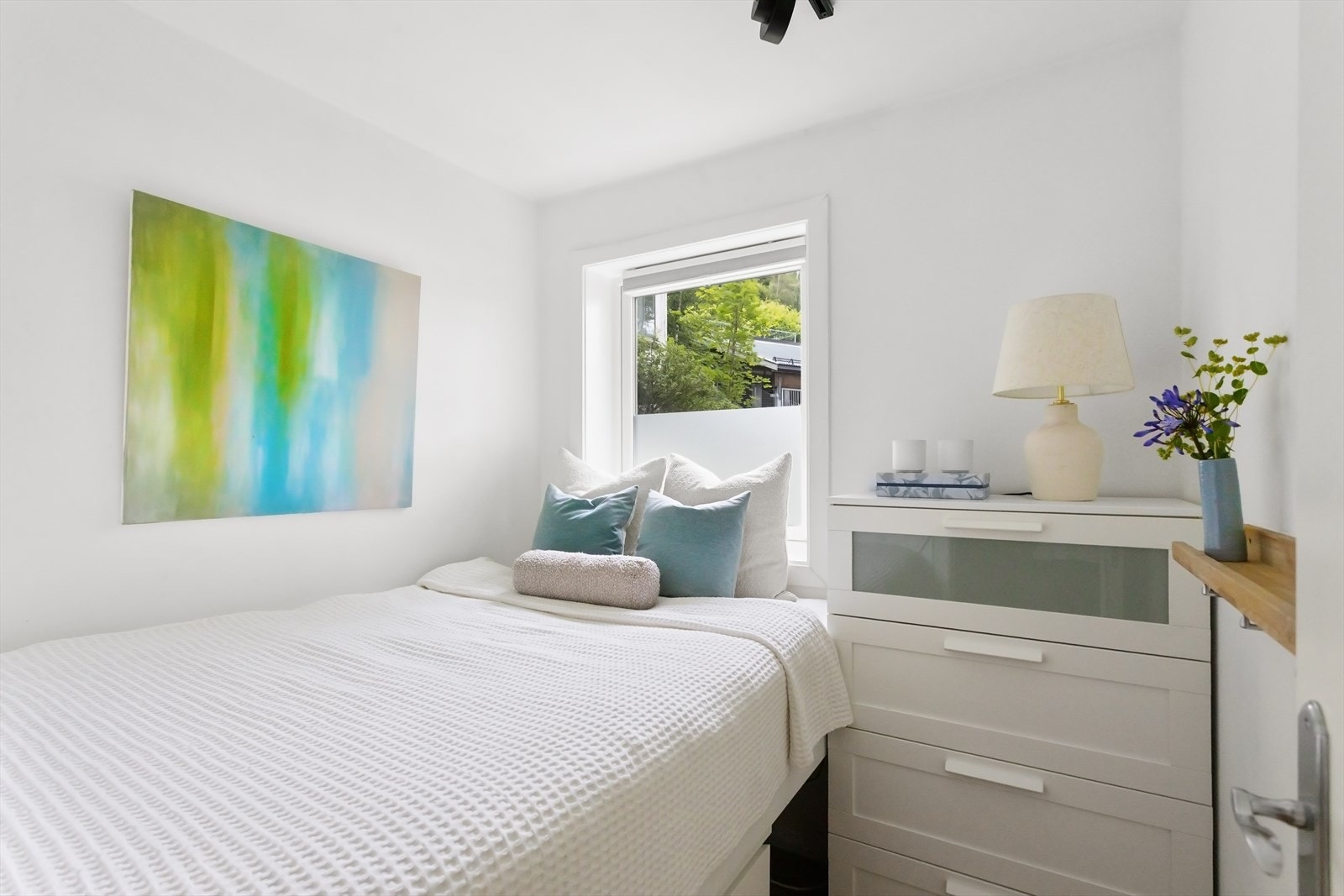 Lyst og luftig soverom med ekstra plass for oppbevaring under seng. Galleribilde