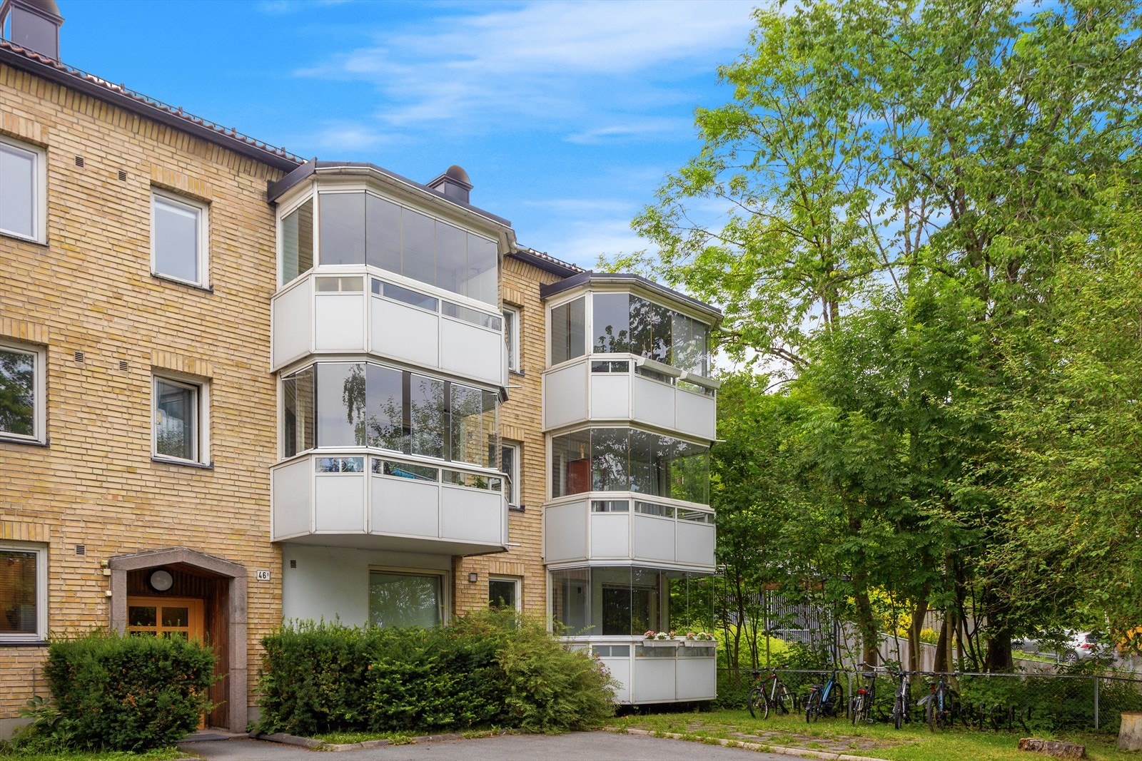 Hyggelig inngangsparti, opparbeidet med beplantning, asfaltert gangsti, sykkelparkering og belysning. Galleribilde