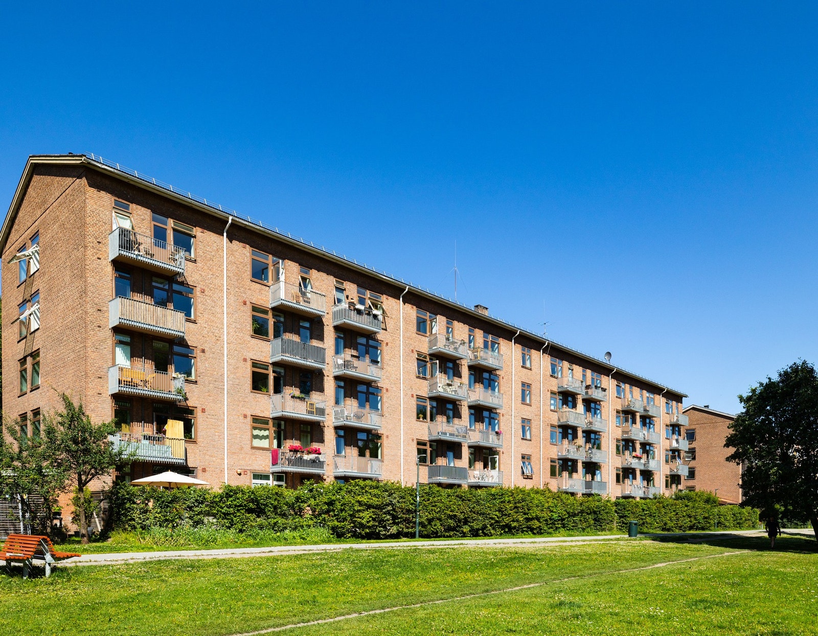 Fasaden mot grøntarealene er omgitt av gressplener, trær og gangveier. Galleribilde