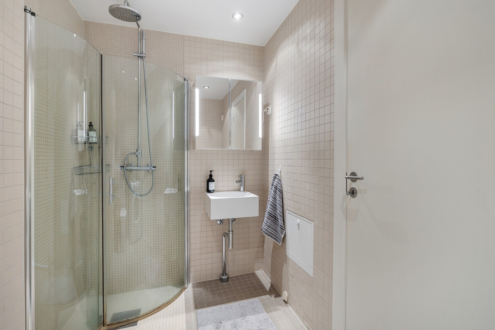 Flislagt bad i lyse toner med moderne innredning. Galleribilde