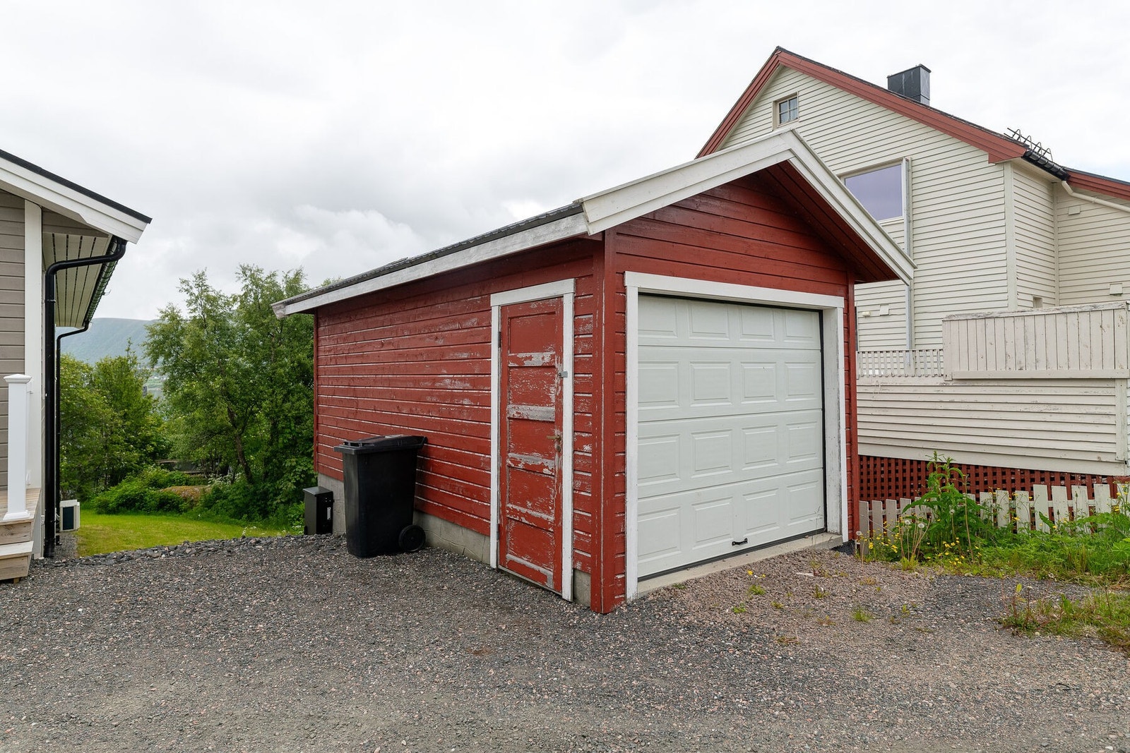 Parkering i garasje fra 2004, tilrettelagt for montering av elbillader. Gruset innkjørsel/gårdsplass. Galleribilde