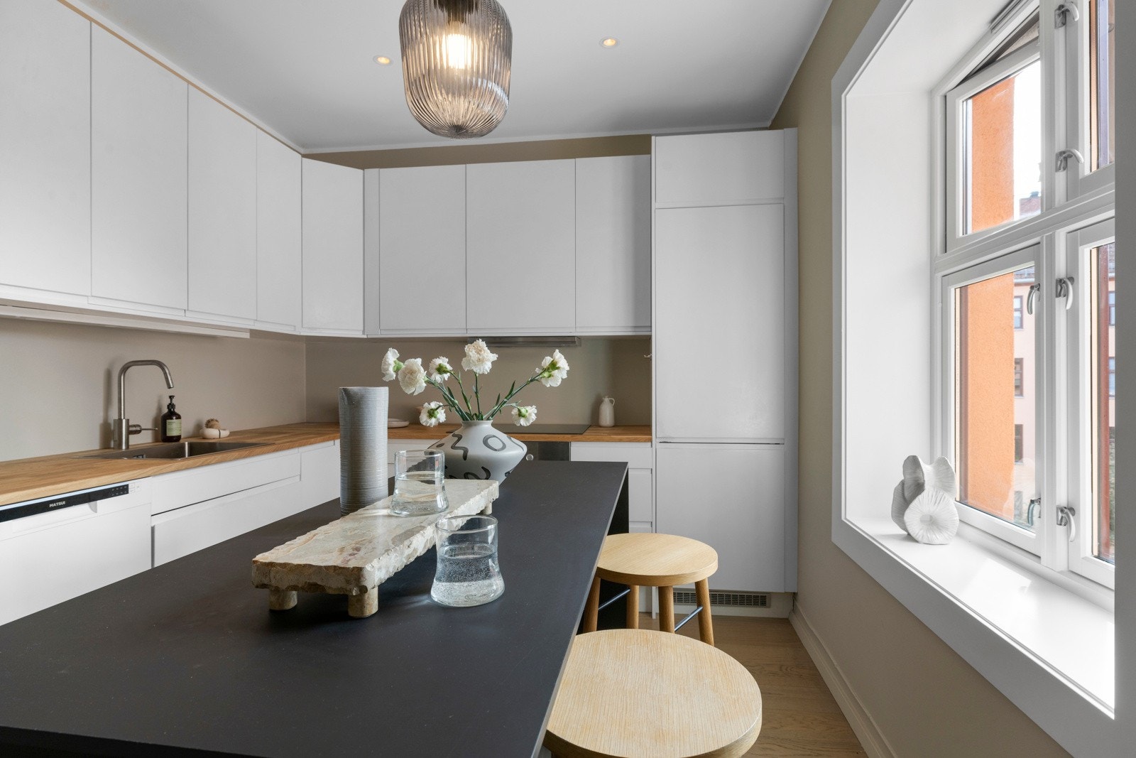 Kjøkkenøyen er perfekt om man vil sitte og nyte frokosten med vinduene åpne mot den rolige bakgården, eller være fler på kjøkkenet for sosial matlaging. Galleribilde