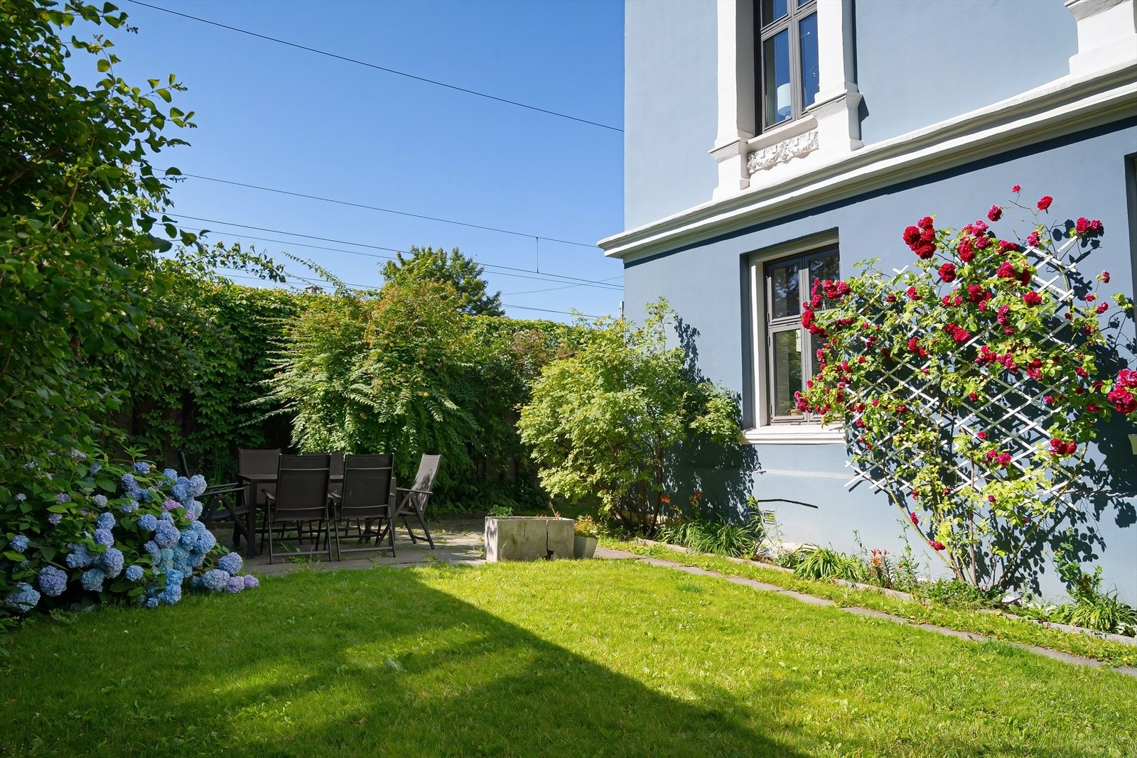 Bakgården er opparbeidet med plen, sittegrupper og beplantning -fungerer som et hyggelig og sosialt samlingspunkt. Galleribilde