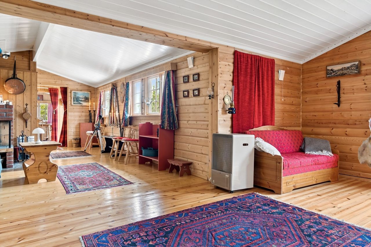 Stuen som var en del av tilbygget fra 1980, romslig med god plass. Rommet har en åpen peis installert mot en brannmur i tegl, som gir god varme. Galleribilde