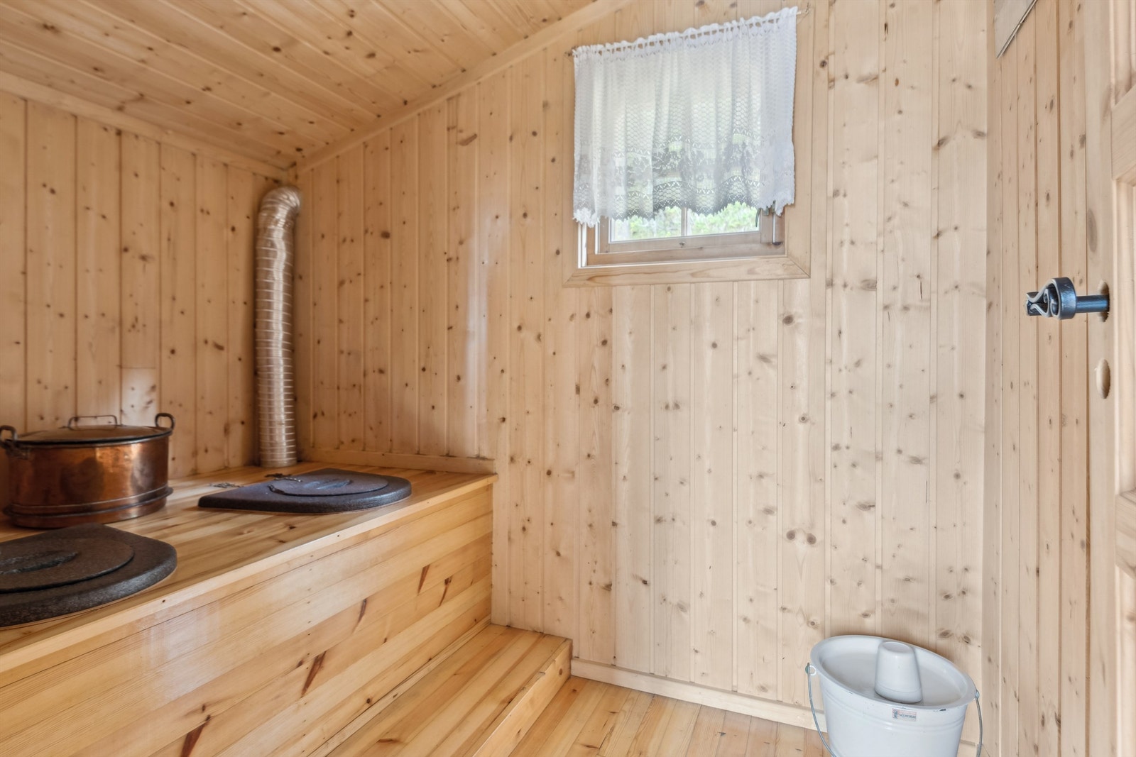 Begge rom har enkle overflater med tregulv og panel på veggene. Galleribilde