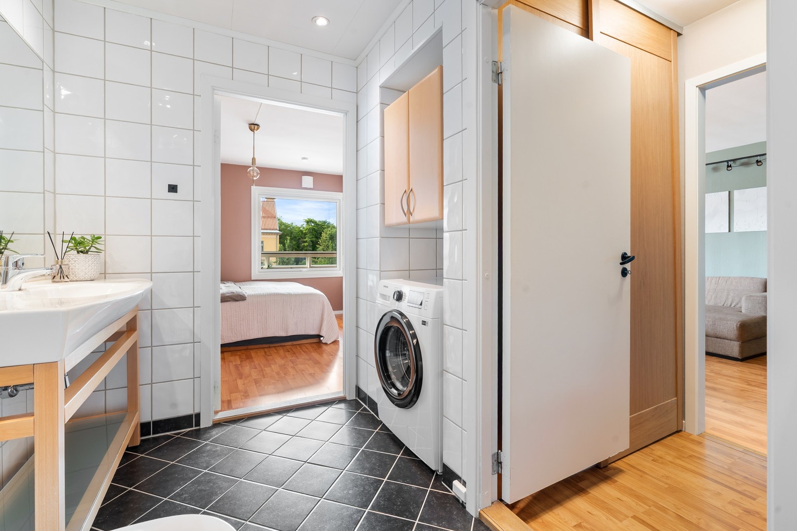 Praktisk vaskesone med opplegg for vaskemaskin og skap for oppbevaring. Galleribilde