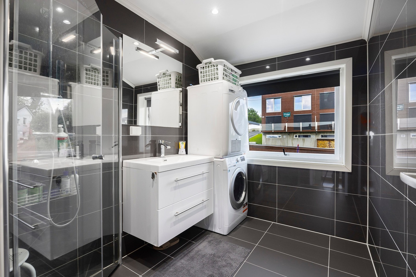 Badet fra 2020 har et lekkert og tidløst uttrykk med mørke fliser og lys innredning. Galleribilde