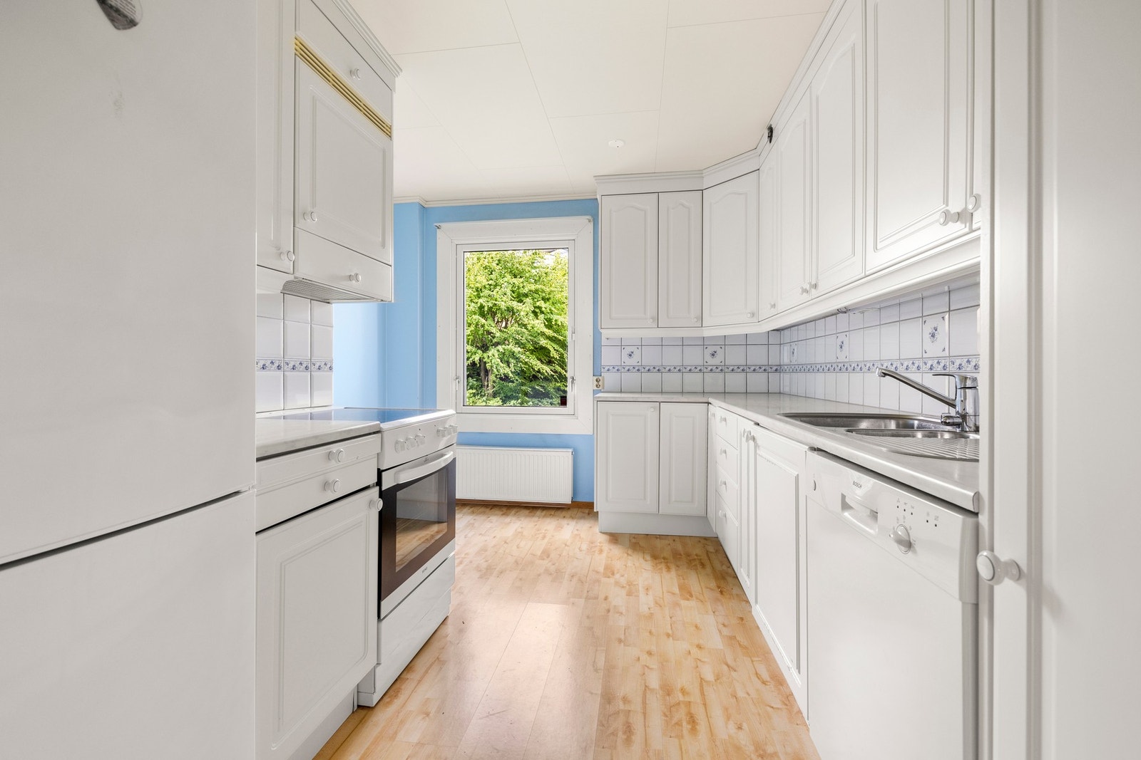 Lyst og pent kjøkken med klassiske hvite fronter. Galleribilde