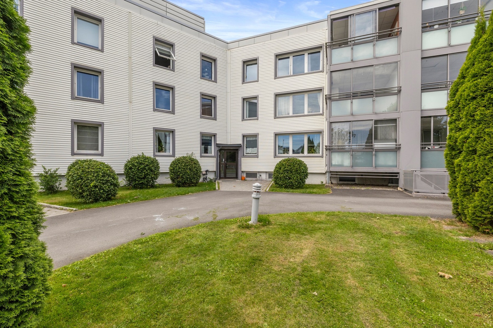 Ryddig og oversiktlig inngangsparti med grønne omgivelser. Galleribilde