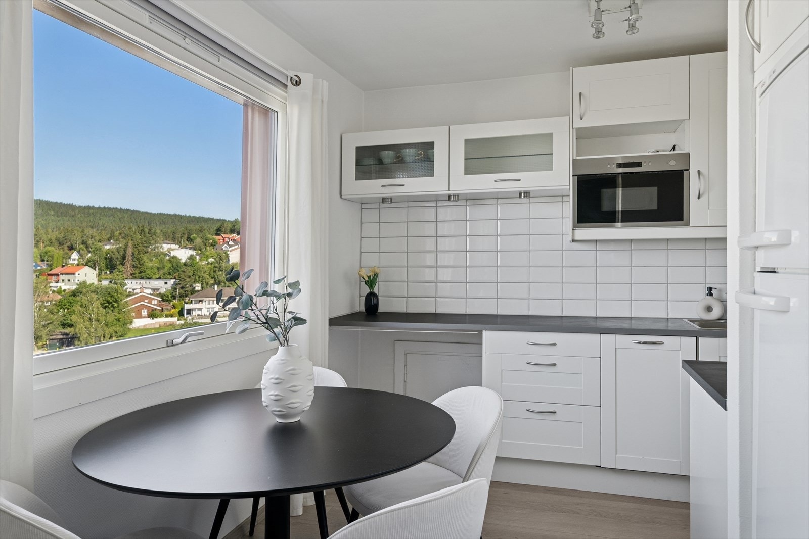 Kjøkkenet fremstår innbydende med plass til praktisk spisebord med utsikt. Galleribilde