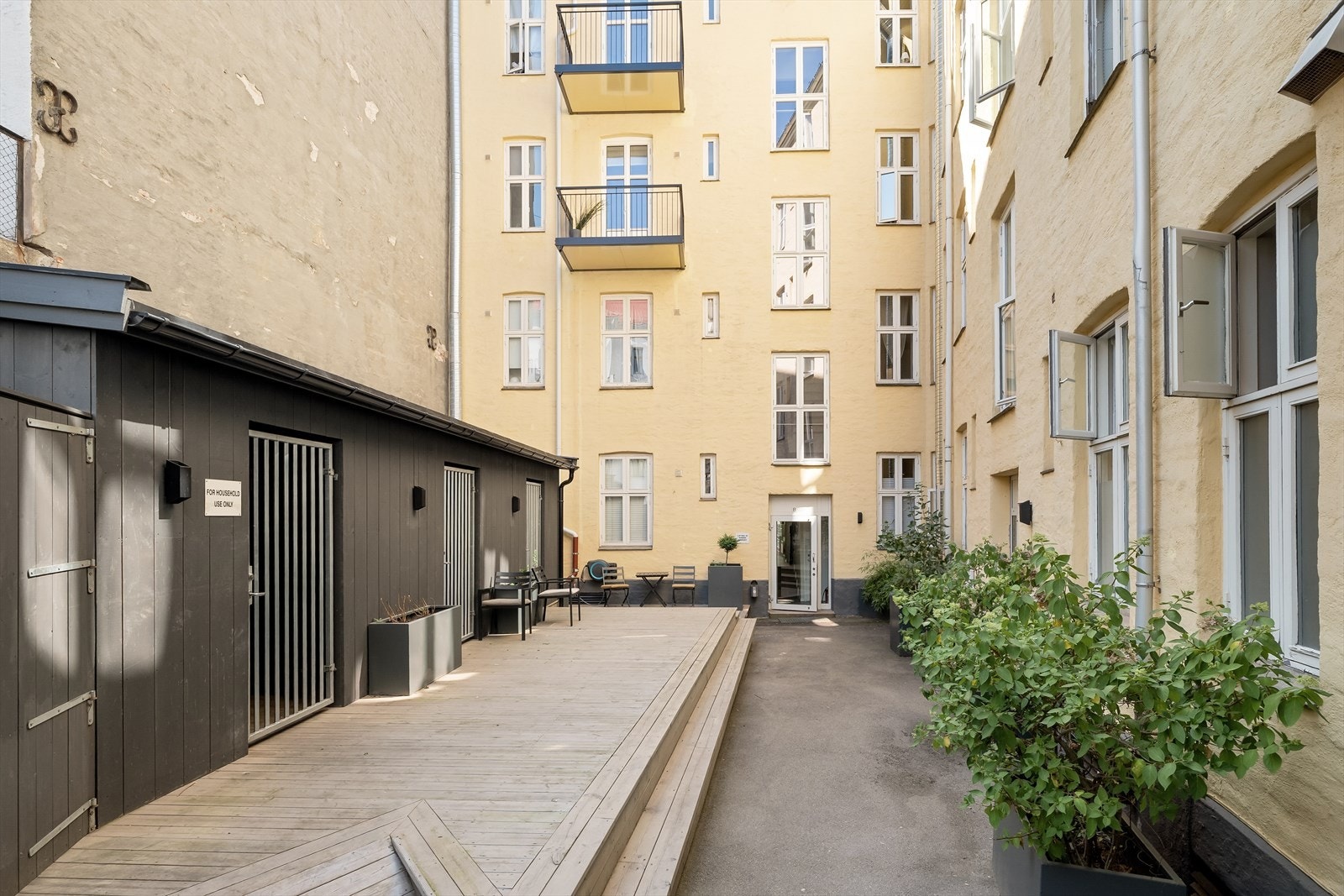 Pent opparbeidet bakgård med boder, platting og søppelskur Galleribilde