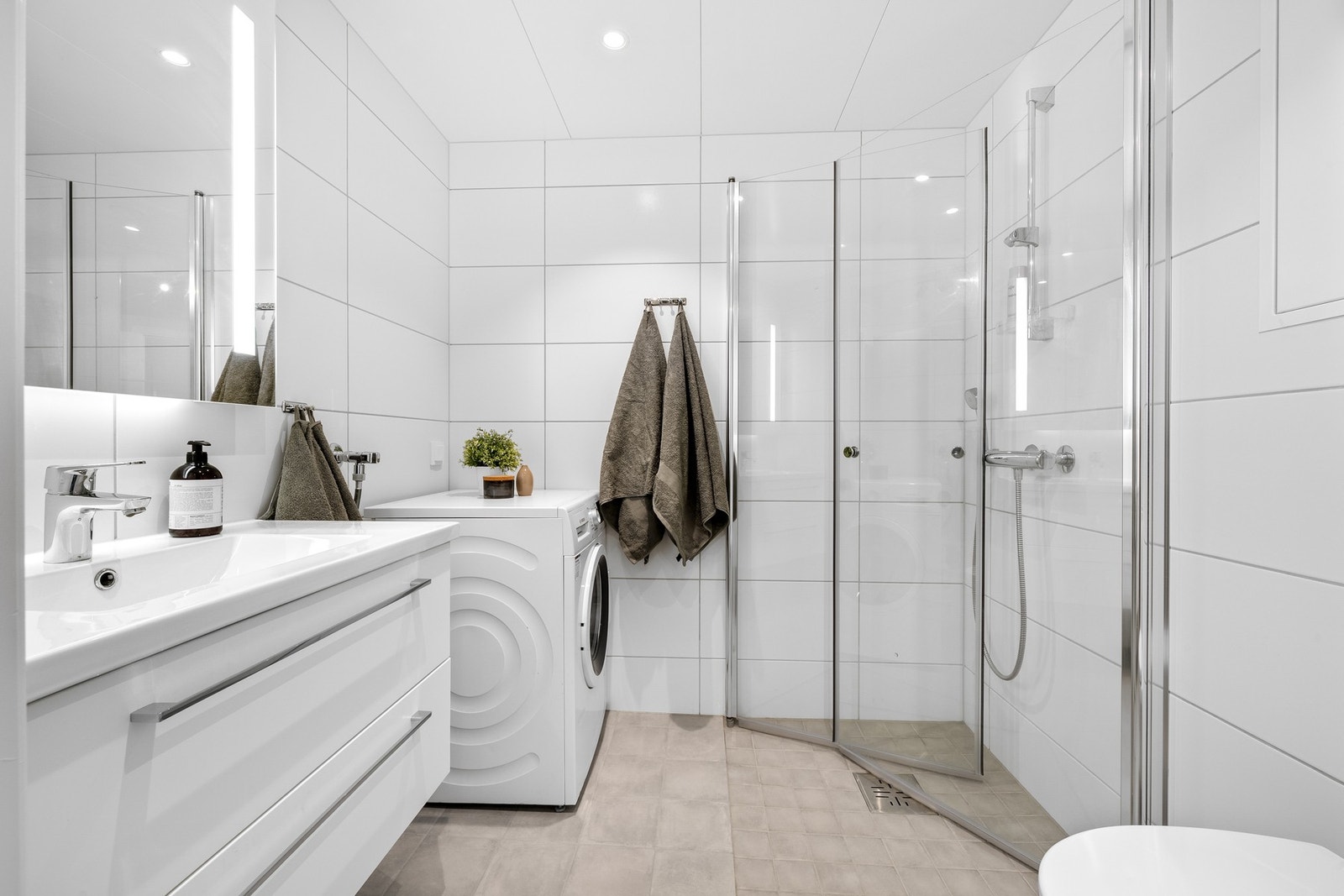 Lyst og innbydende bad med opplegg til vaskemaskin og behagelig varme i gulv. Galleribilde