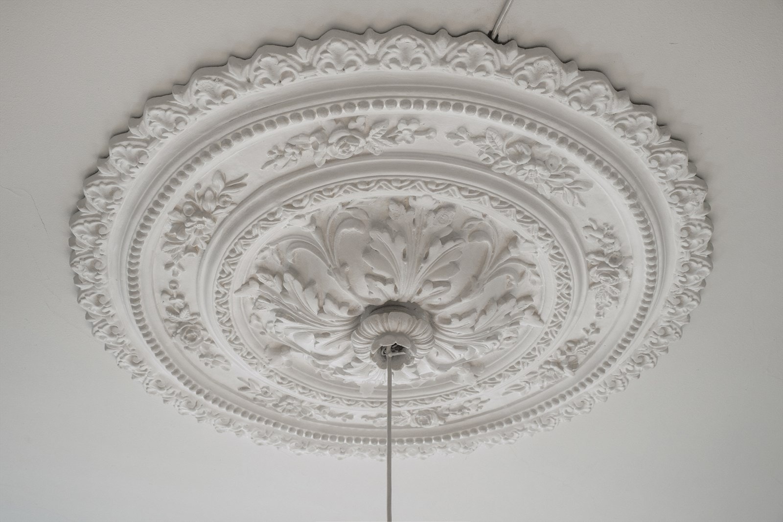 Takrosett i klassisk stil med elegant utsmykning som gir rommet et historisk preg Galleribilde