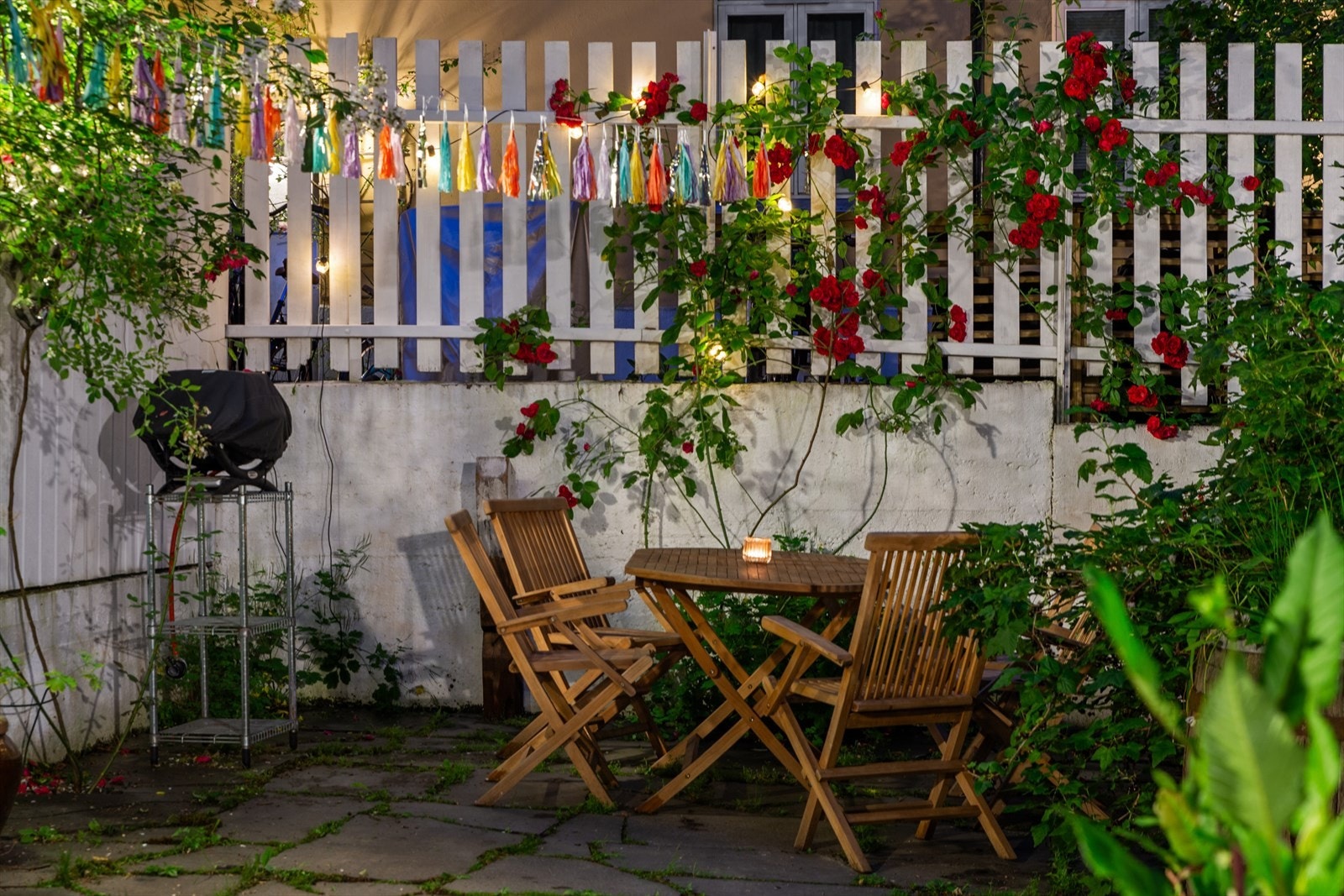 Bakgården er pent beplantet med blant annet lekre klatreroser Galleribilde