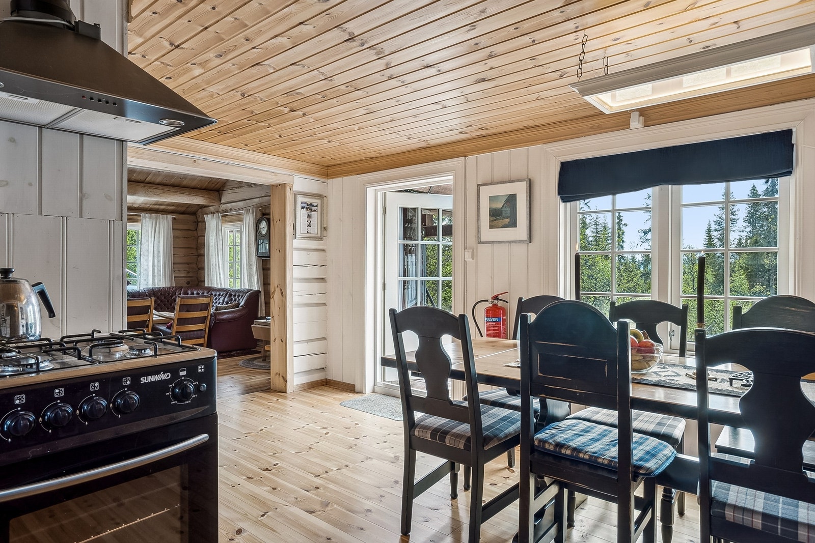 Vann til vasken hentes fra en kanne i benkeskapet med en manuell håndpumpe. En kjøkkenventilator med avtrekk ut er montert over komfyrplassen. Galleribilde